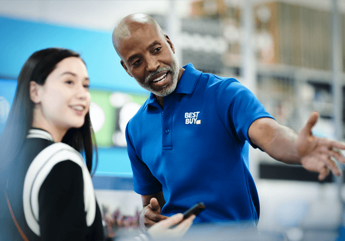 A Best Buy associate helping a customer at a product display