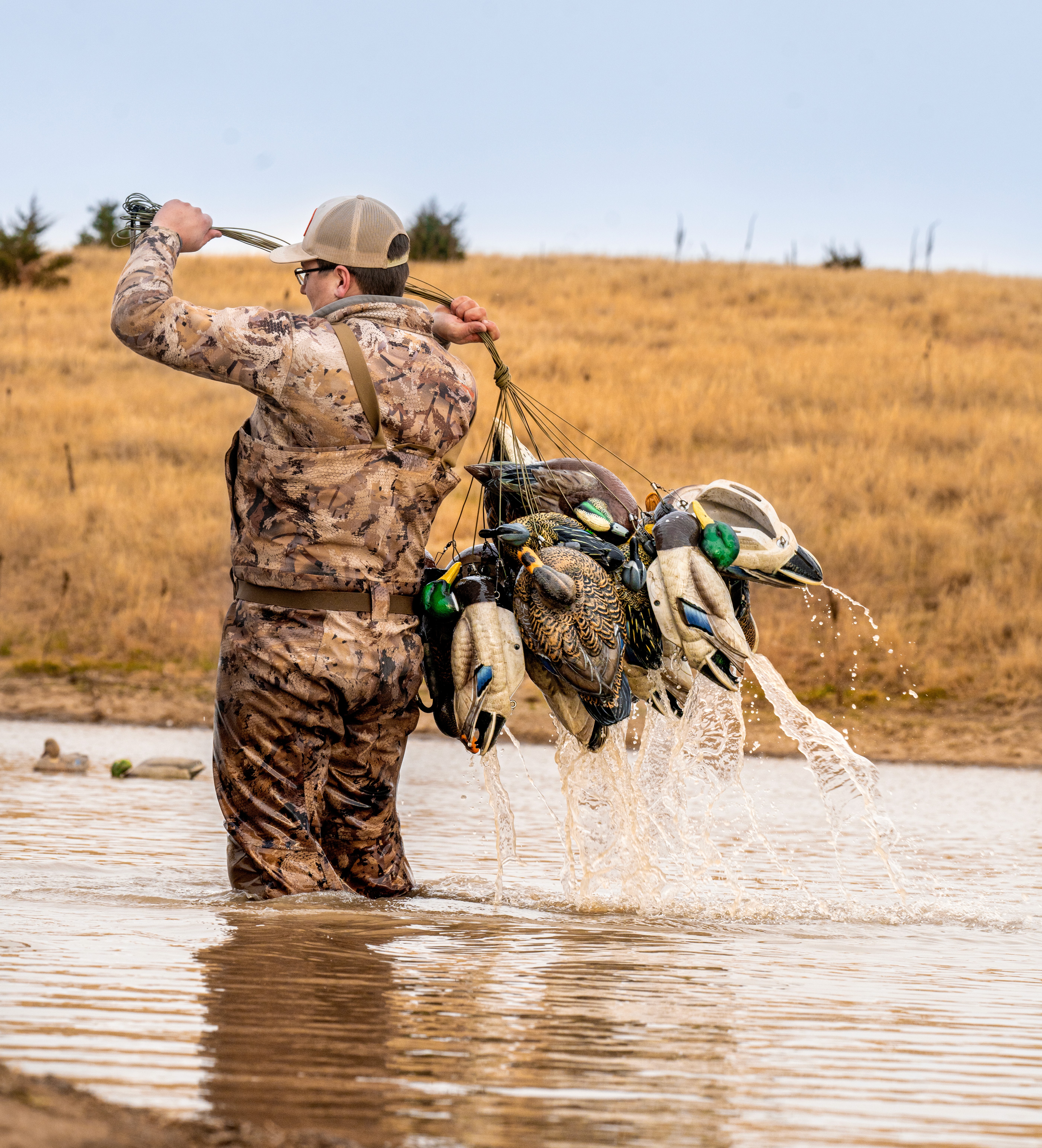Black and white photo of two people looking at a computer screen with papers on wall