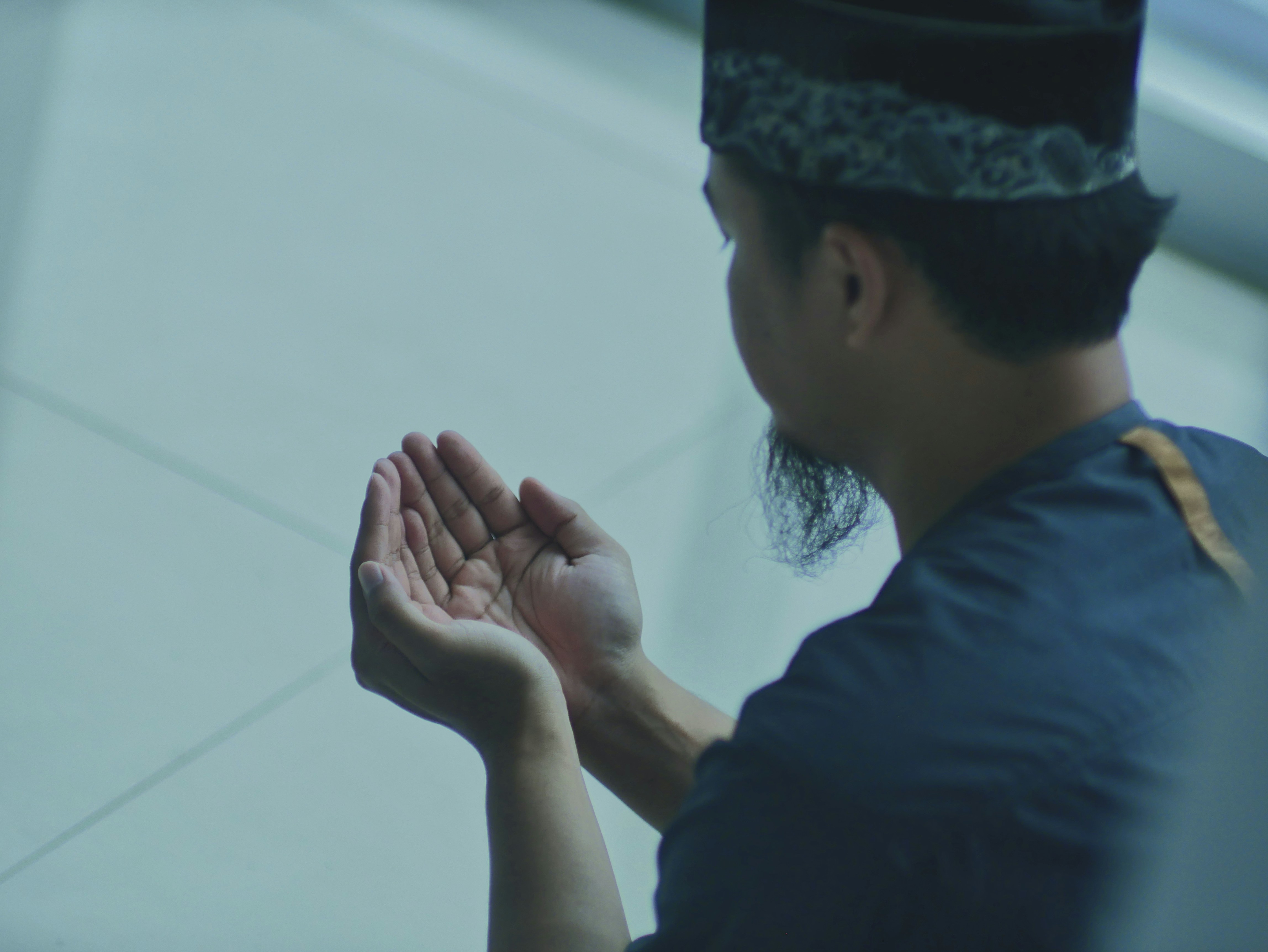 a man in a blue shirt is holding his hands together