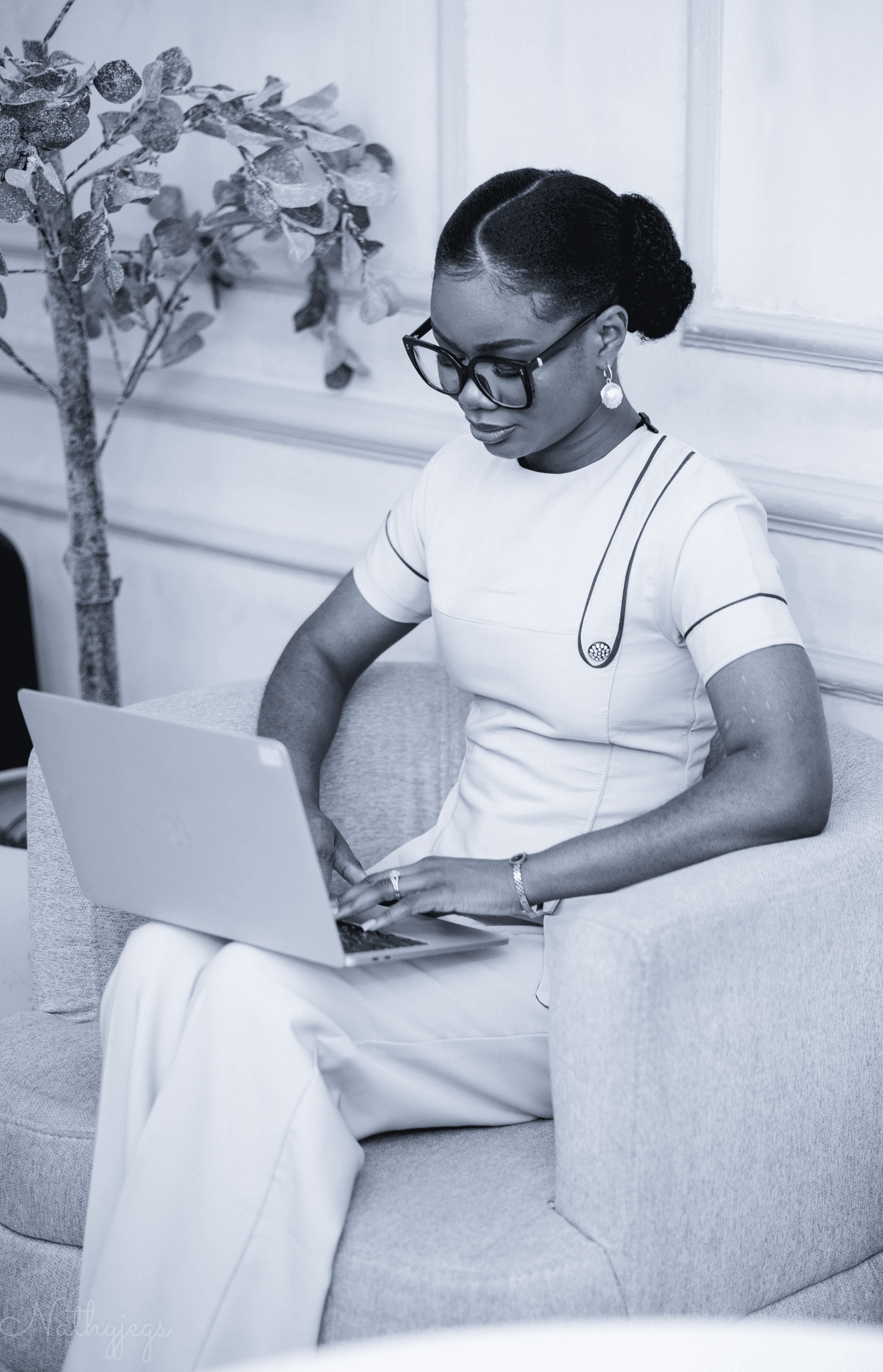 Portrait of Sandra Osaretin, a UI/UX and brand designer, working on a laptop