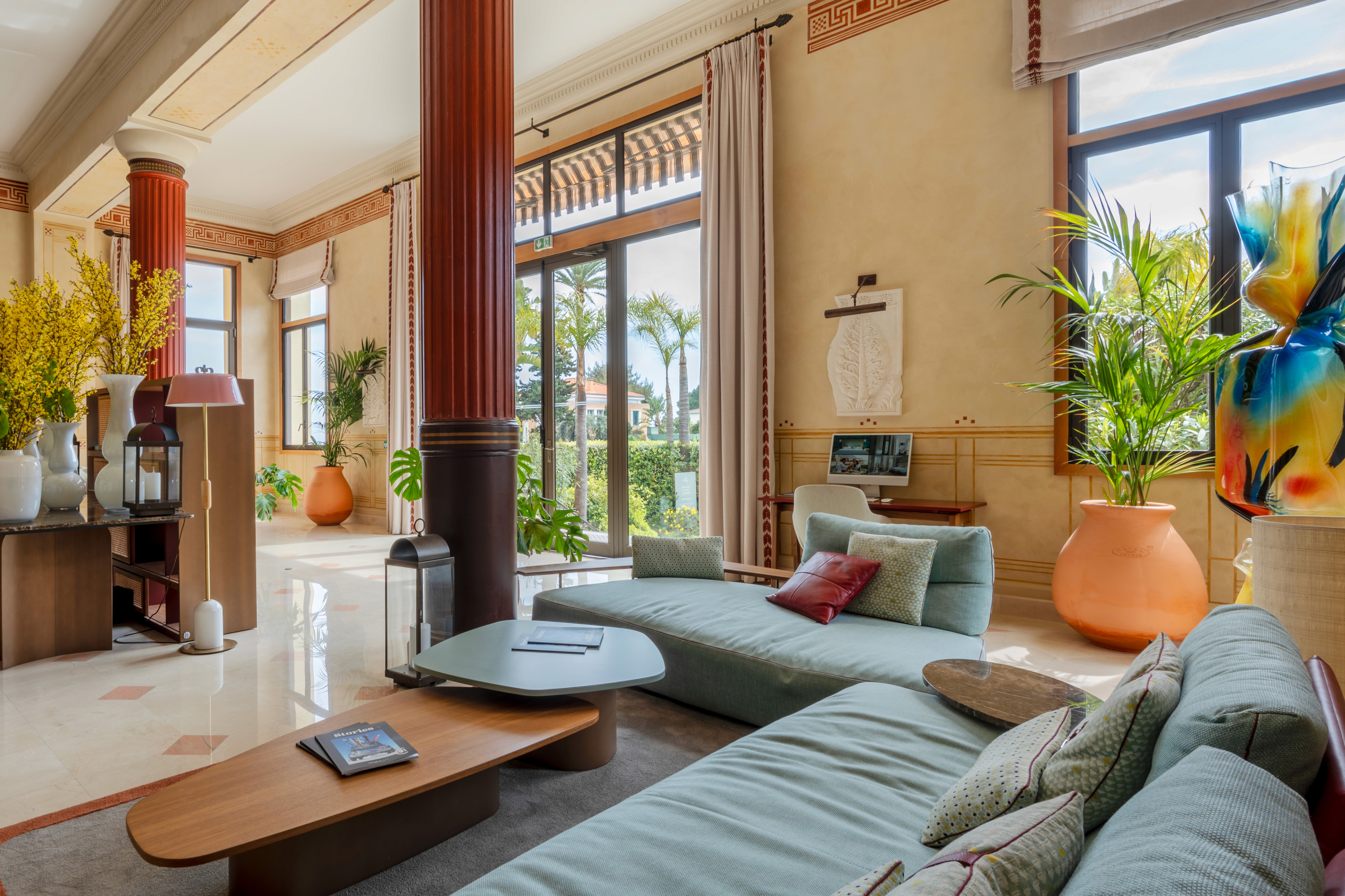 Elegant lounge seating inside Royal Riviera Hotel lobby with artwork and natural light