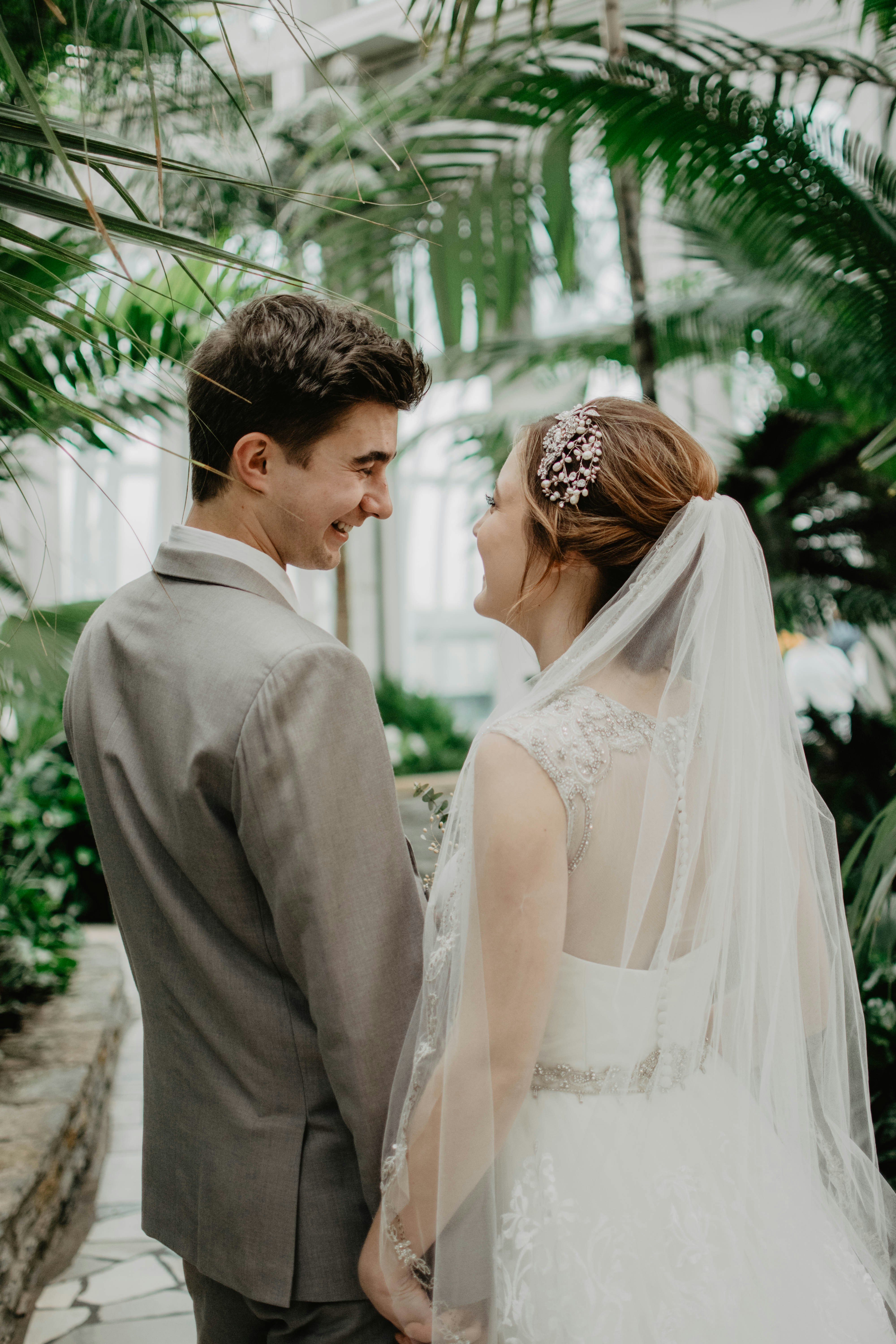 A bride and groom share a kiss surrounded by a joyful bridal party.