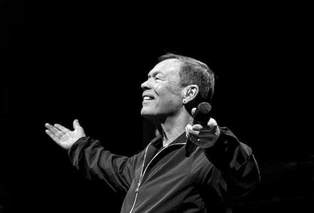 Man rapping into microphone on stage