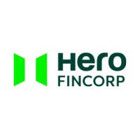A smiling woman with her arms crossed, standing against a dark green background. She has long, dark hair.
