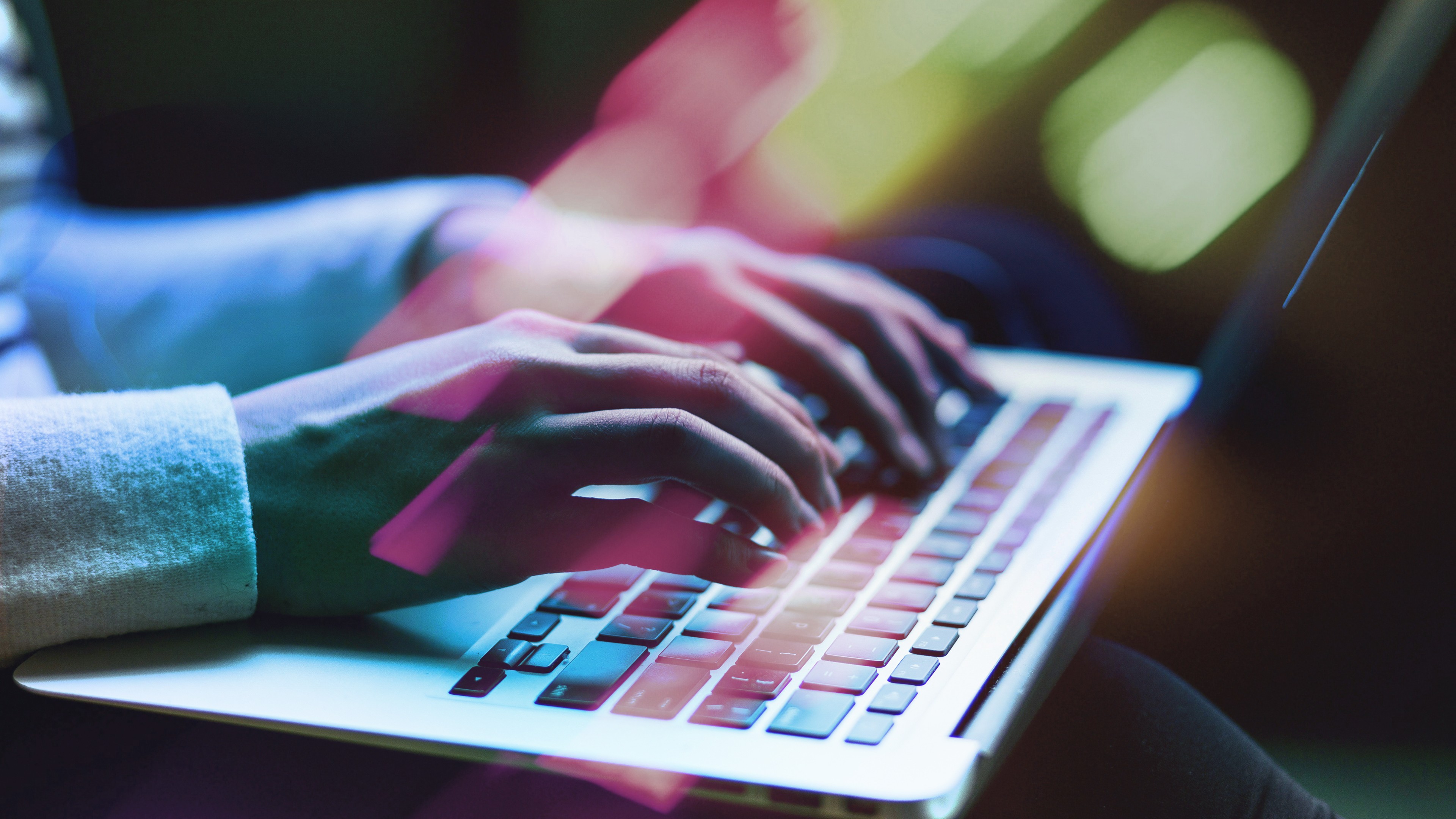 Close up of hands typing at a laptop keyboard