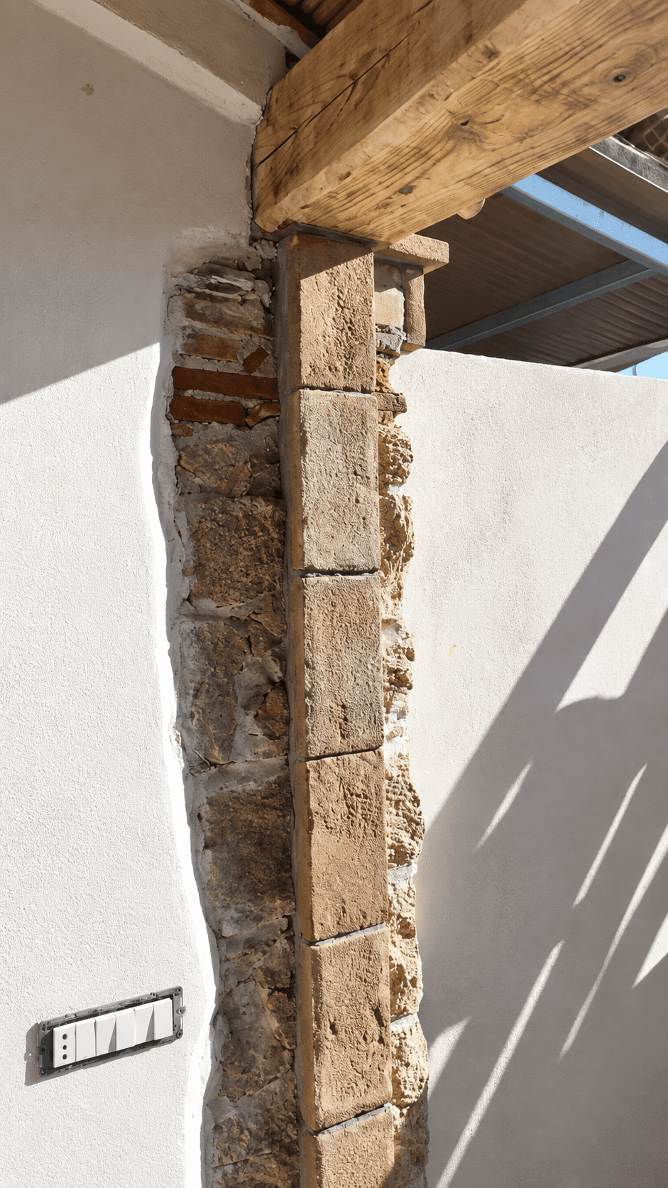 Dettaglio della trave in legno e del pilastro in pietra prima dell’installazione della vetrata.