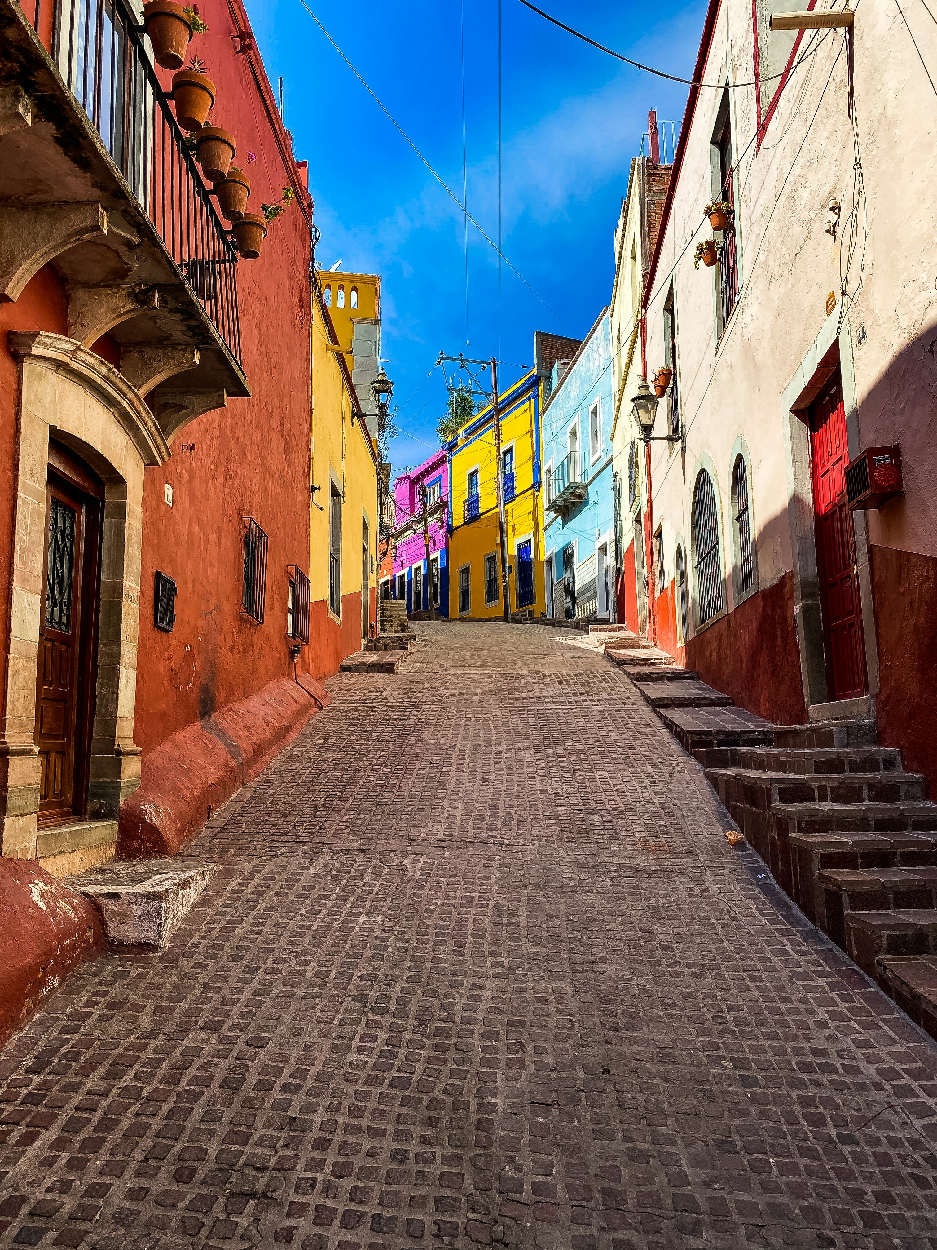 empty bricked road by buildings at daytime