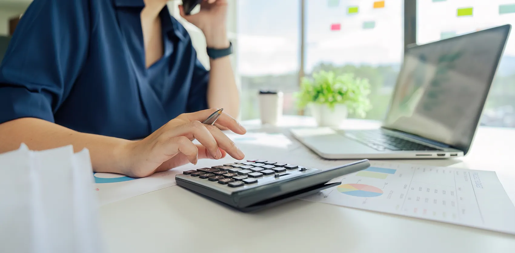 Hand, die auf Taschenrechner tippt