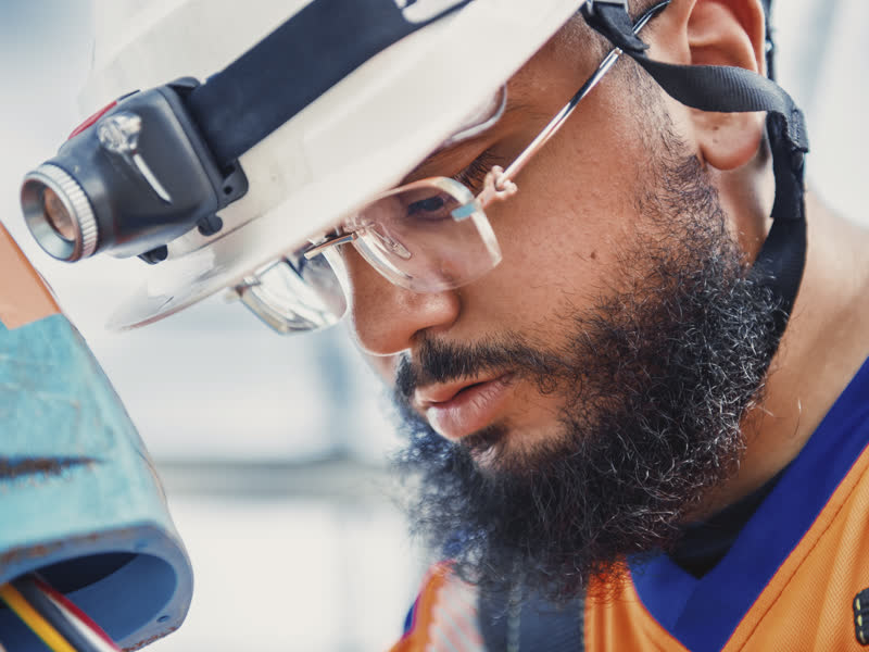 Portrait d'un électricien en lunettes de protection sur un site industriel