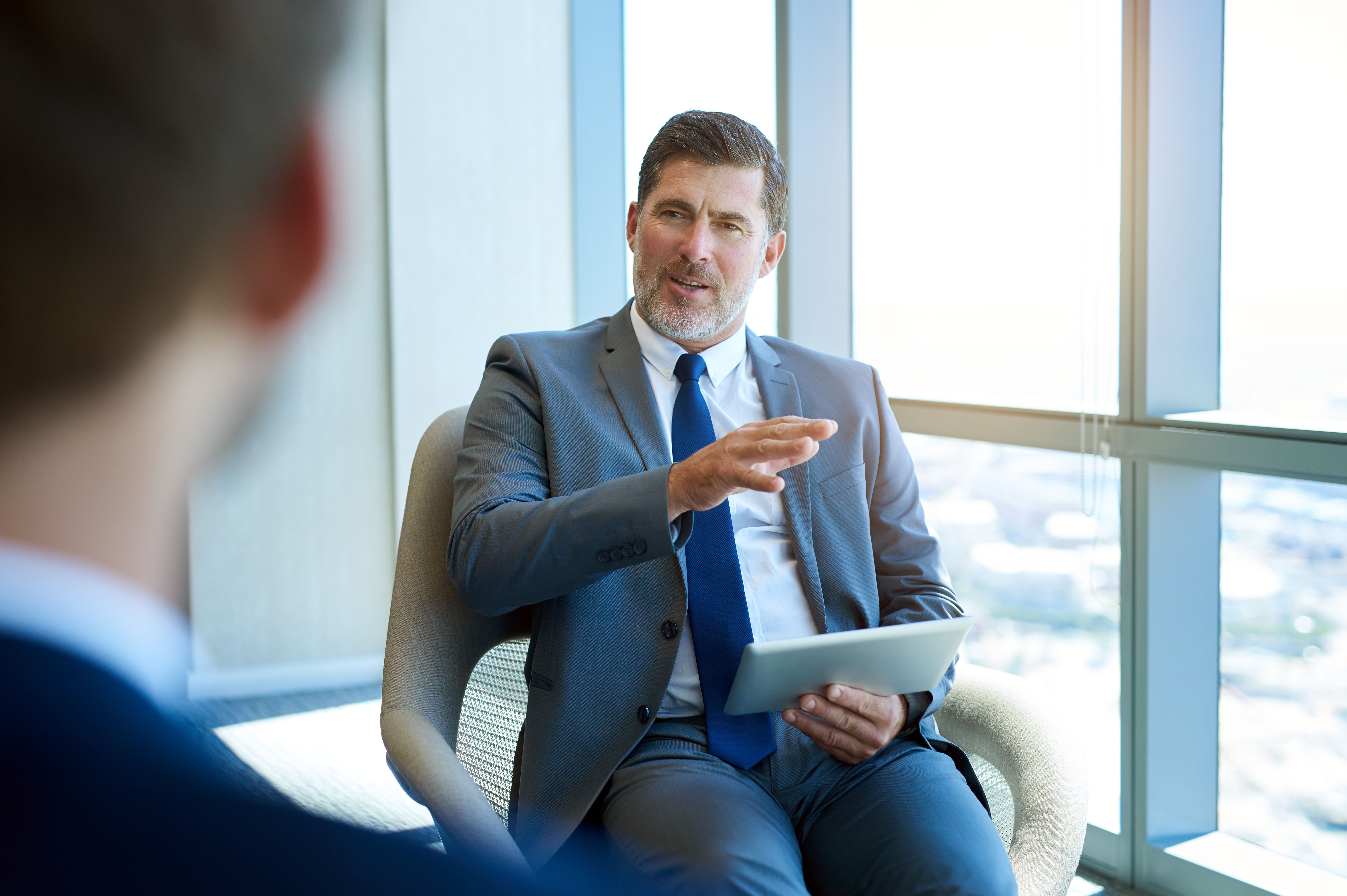 Auditor im Gespräch mit einer Person der obersten Leitung über Führungsverantwortung, Governance-Verantwortung und Politik des Managementsystems