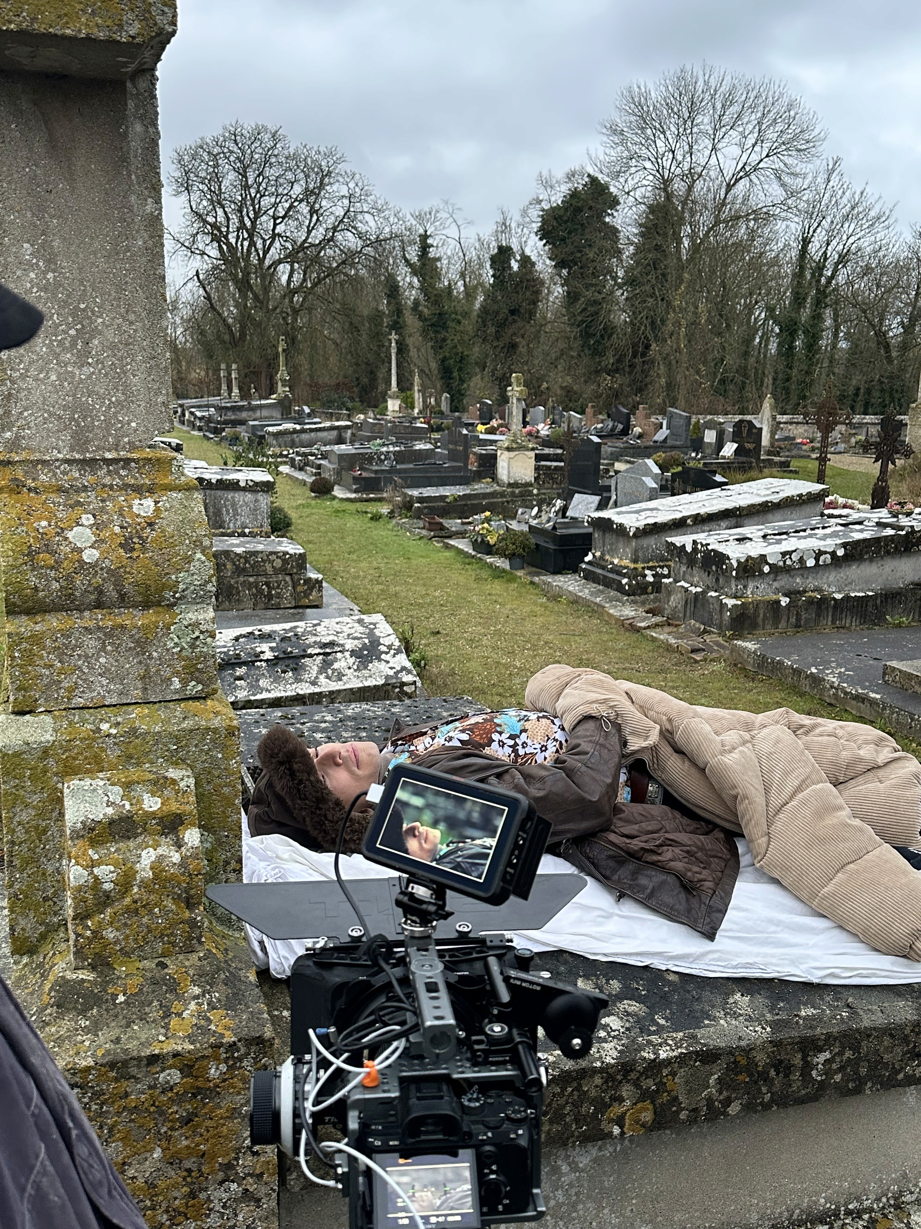 Woman in pink leather jacket crouching outdoors at night