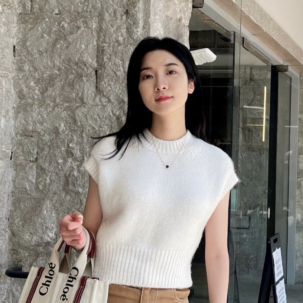 asian woman with white shirt and brown pants holding a bag