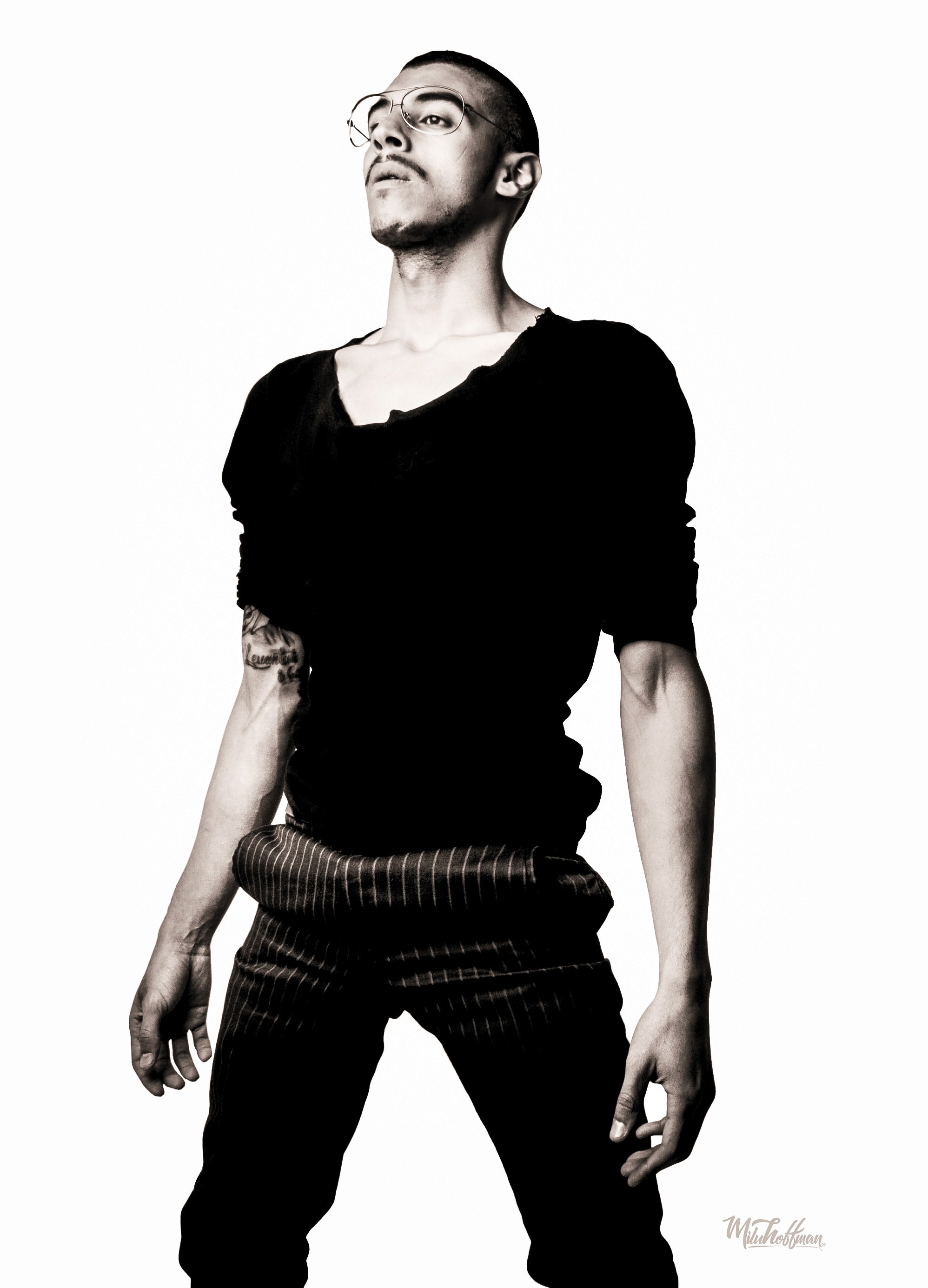 Low-angle studio portrait in black and white, emphasizing the subject's silhouette and strong jawline through high-precision lighting and post-production tonal control.