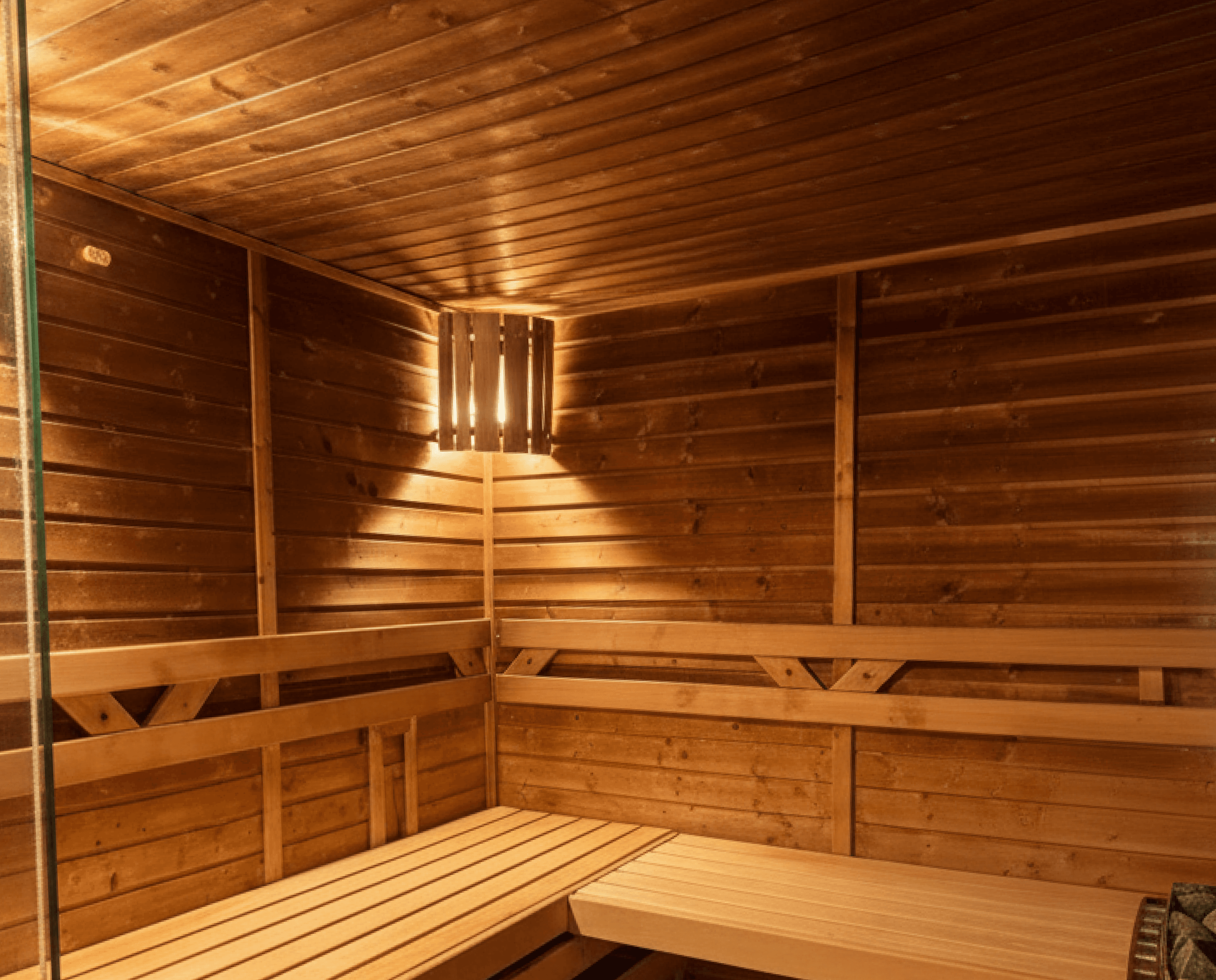 Finská sauna ve Fitness Milovice s dřevěným interiérem a lavicemi pro klidnou regeneraci.