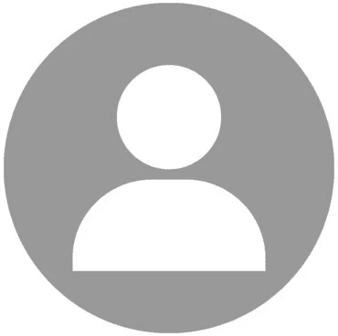 Editorial portrait of a young man with wavy hair in a knit sweater, looking over his shoulder in soft light.