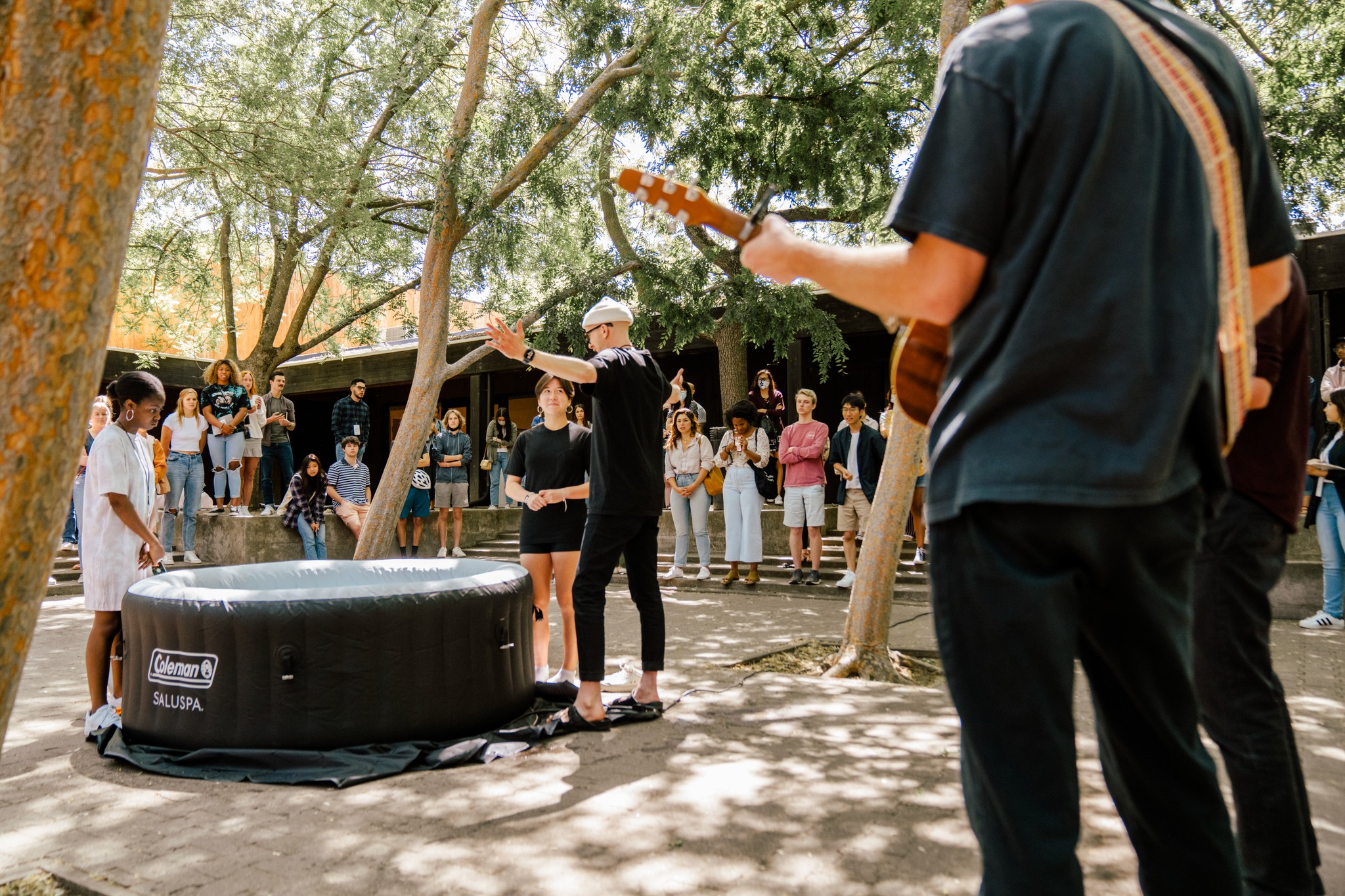 two people in a workspace working on their laptops