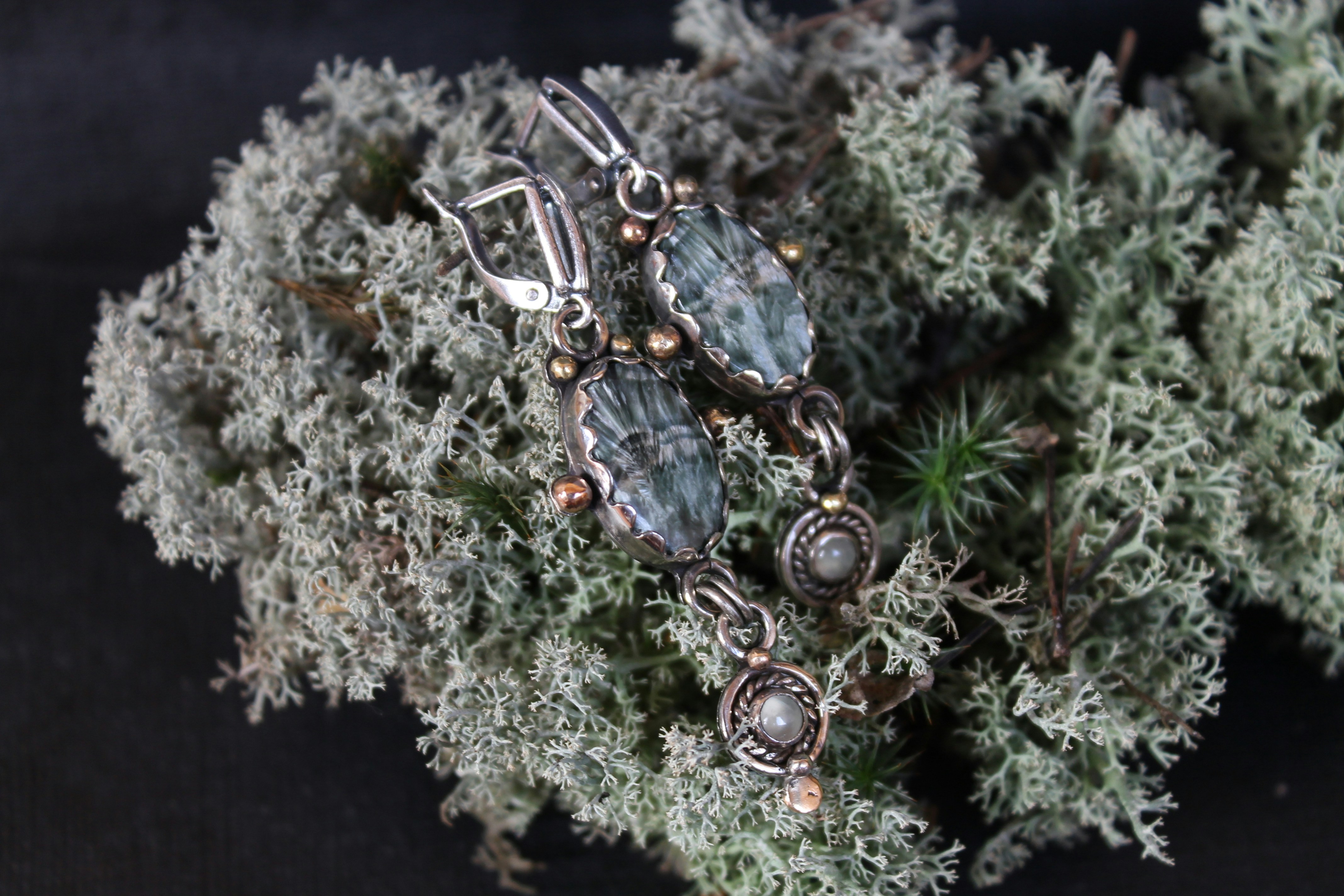Elegant earrings resting on natural moss
