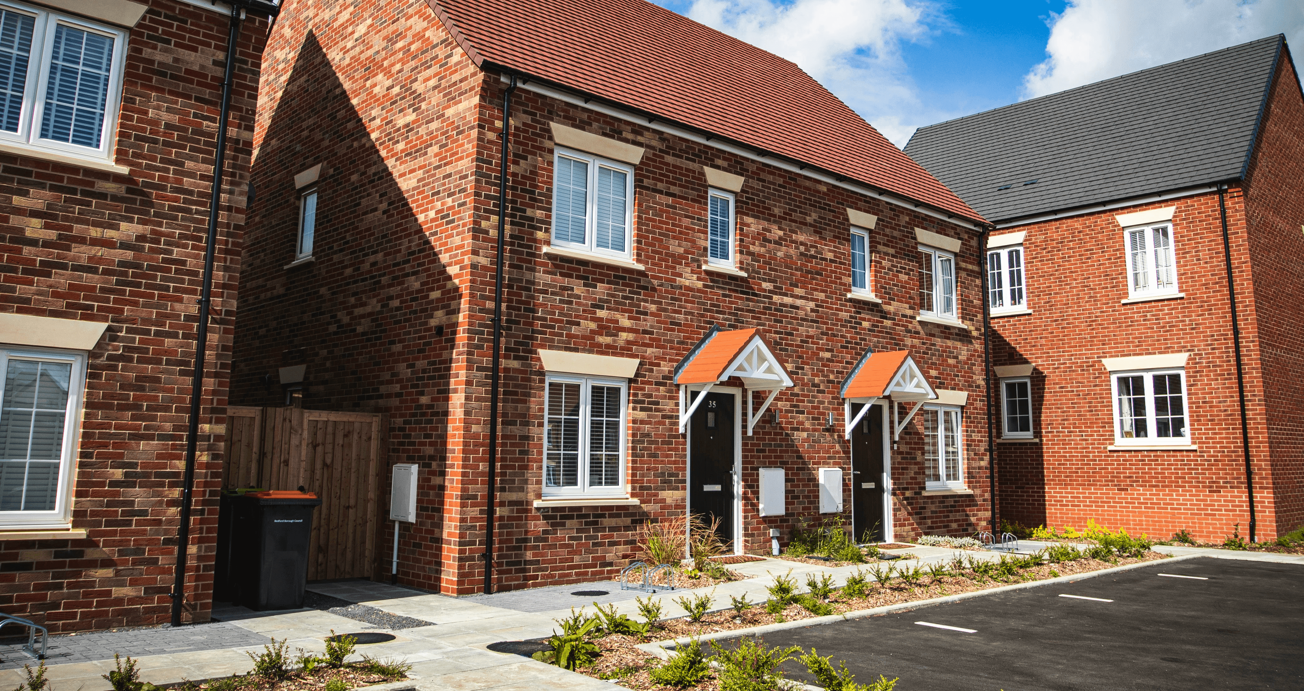 Brick house with stone path and parking spaces out front.