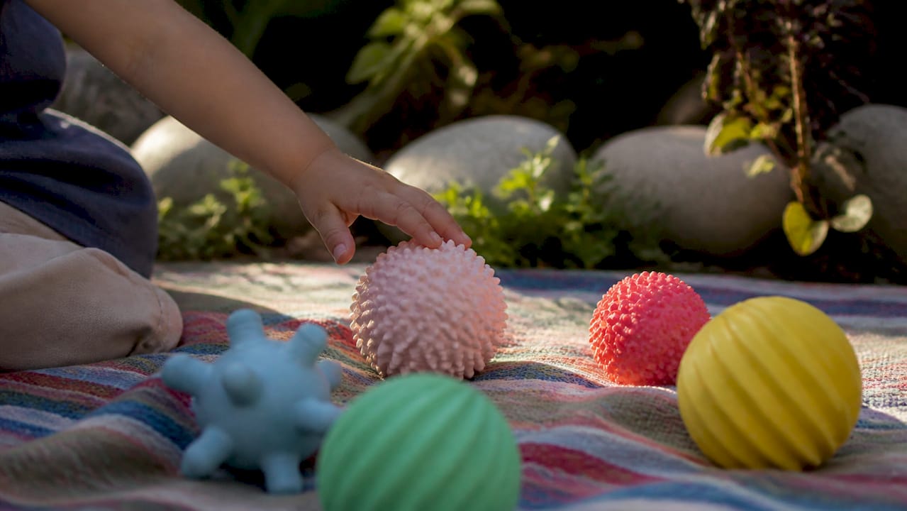 Niño jugando con una pelota sensorial