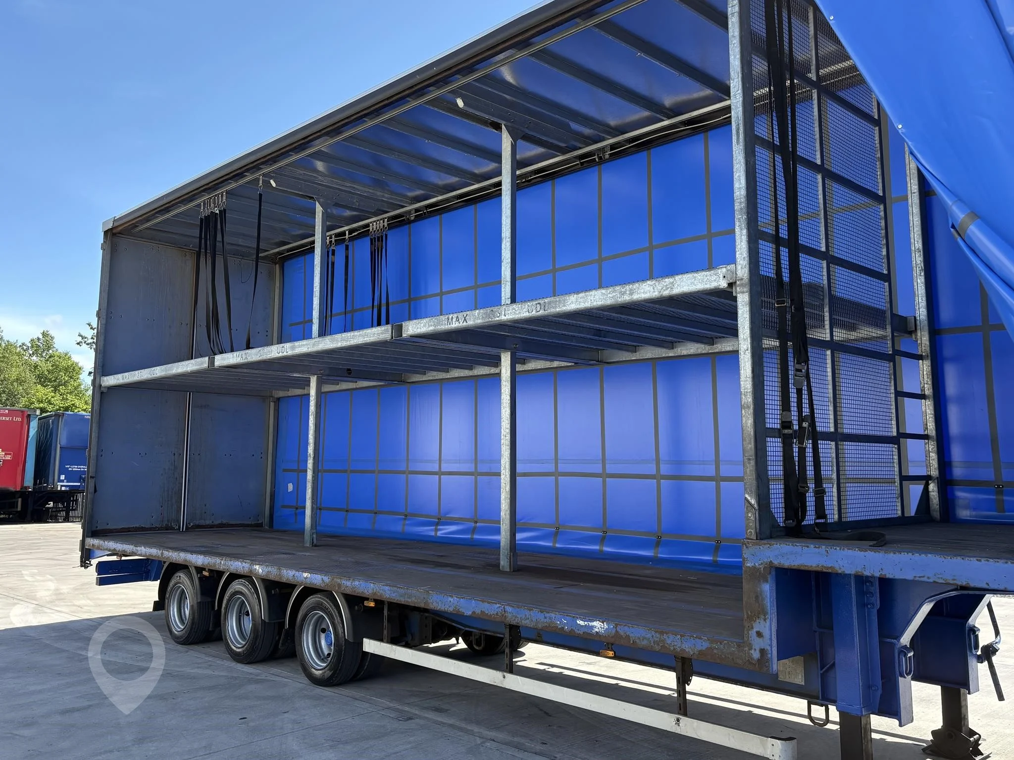 An image of a double decker trailer with one of its curtains open so you can see the multi layers inside 