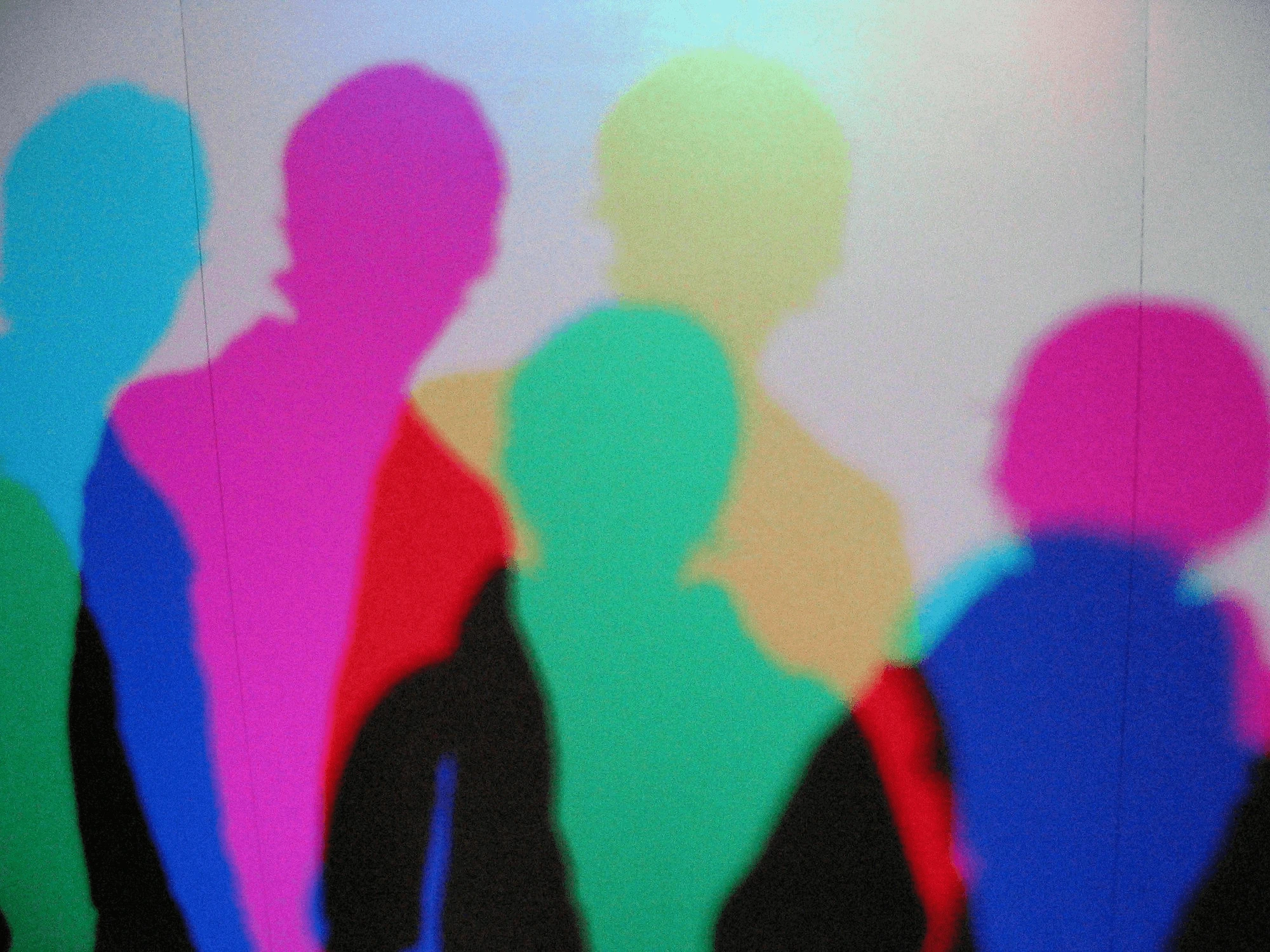 Abstract visual of multiple neon coloured silhouettes of peopl
