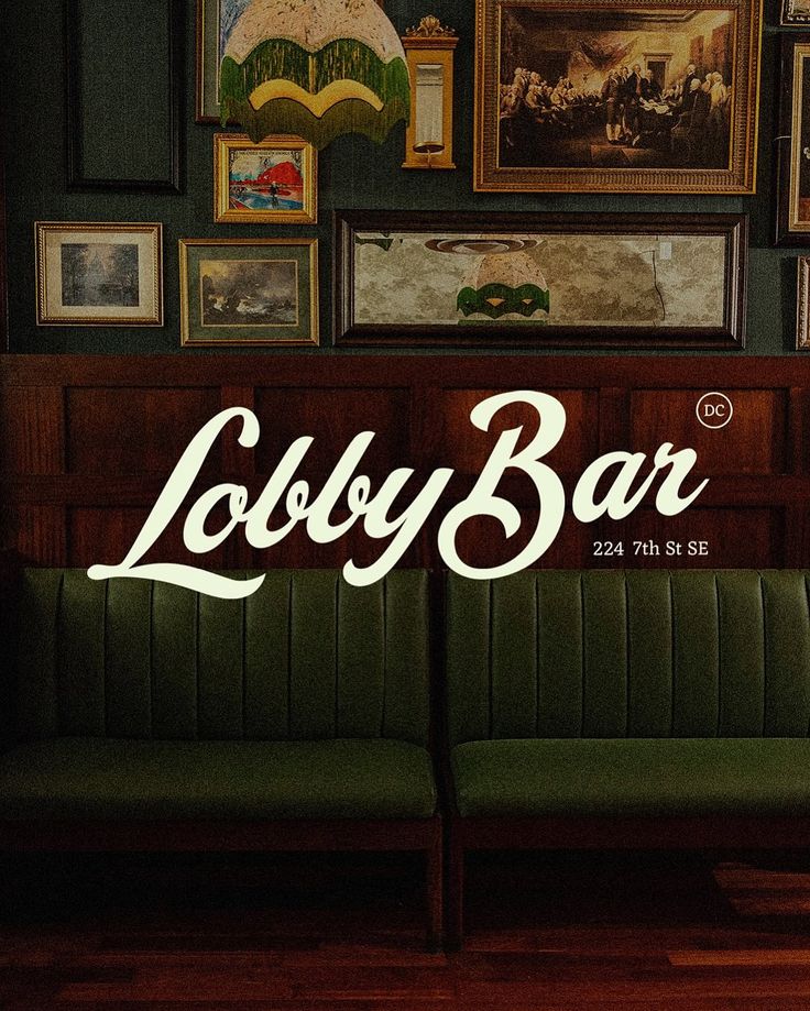 A young man with light brown hair is wearing a black suit jacket and white shirt, standing in a softly lit office setting, conveying professionalism.