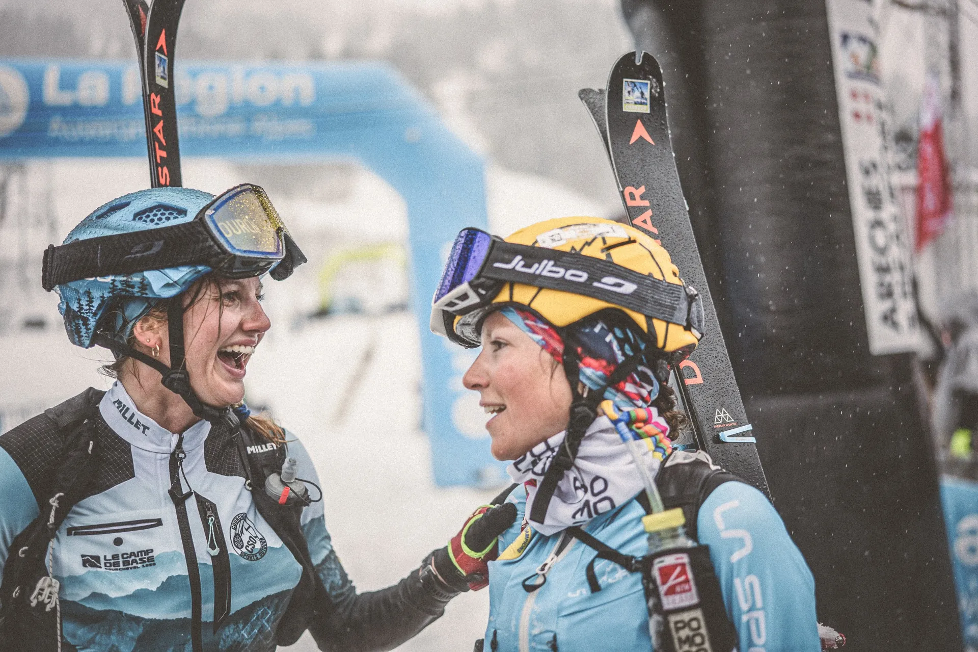Two Julbo athletes congratulating each other at the Pierra Menta finish line - smiling after the race, captured by Outdoor Perspectives