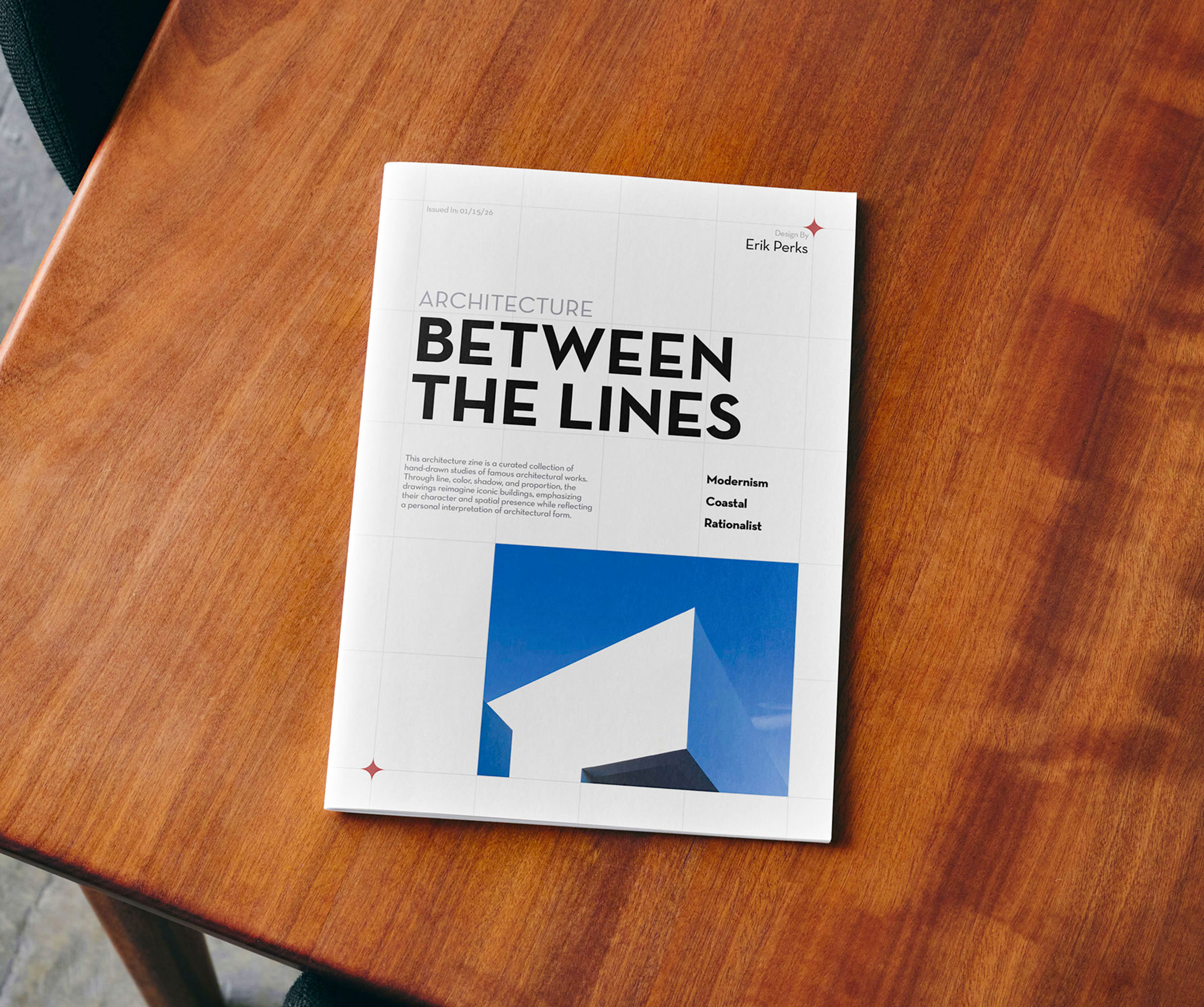 Magazine titled "Architecture Between the Lines" on a wooden table. The cover features bold text and a minimalist building image, conveying a modern, professional tone