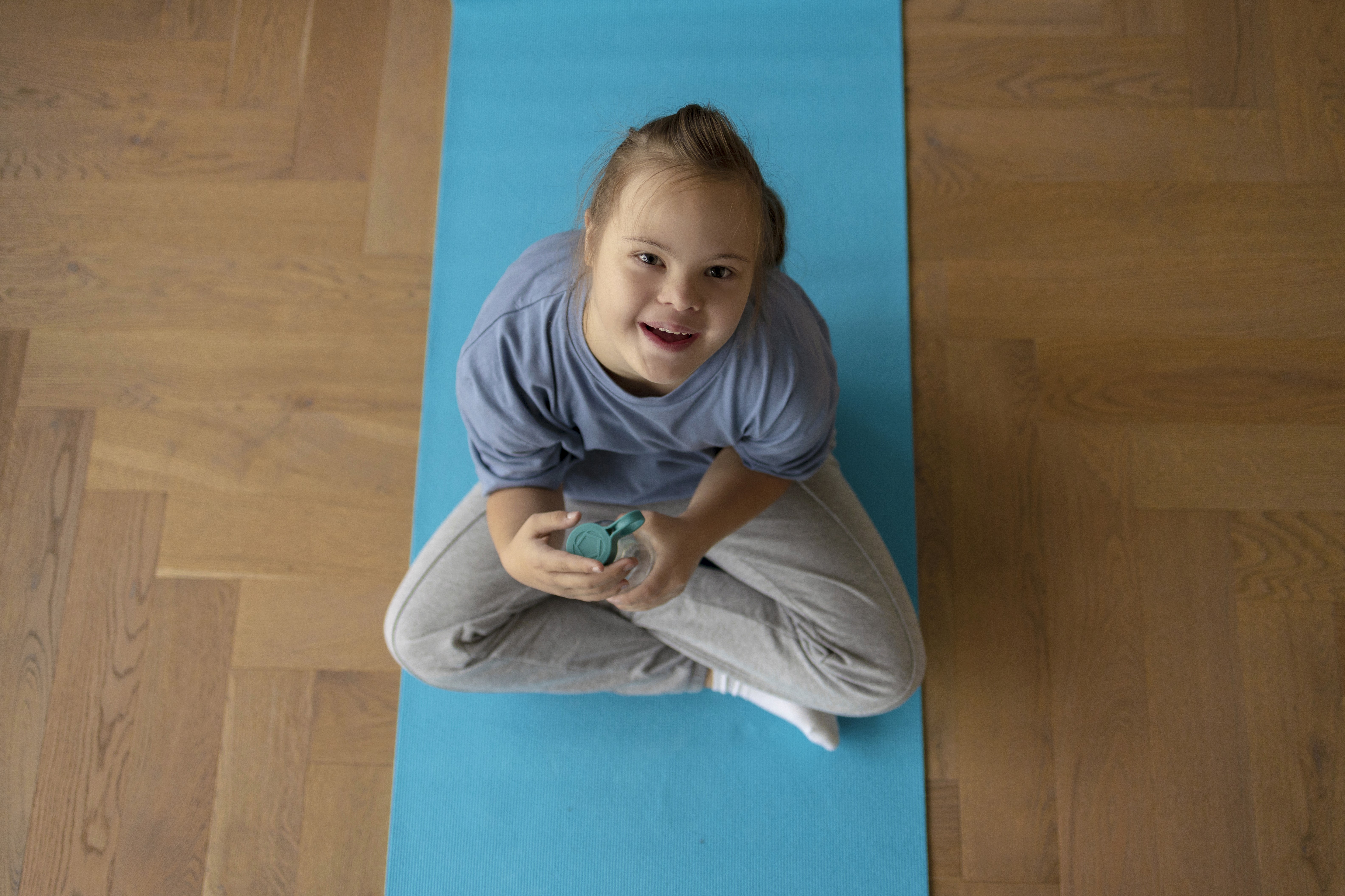 A young woman with down syndrome smiles warmly.
