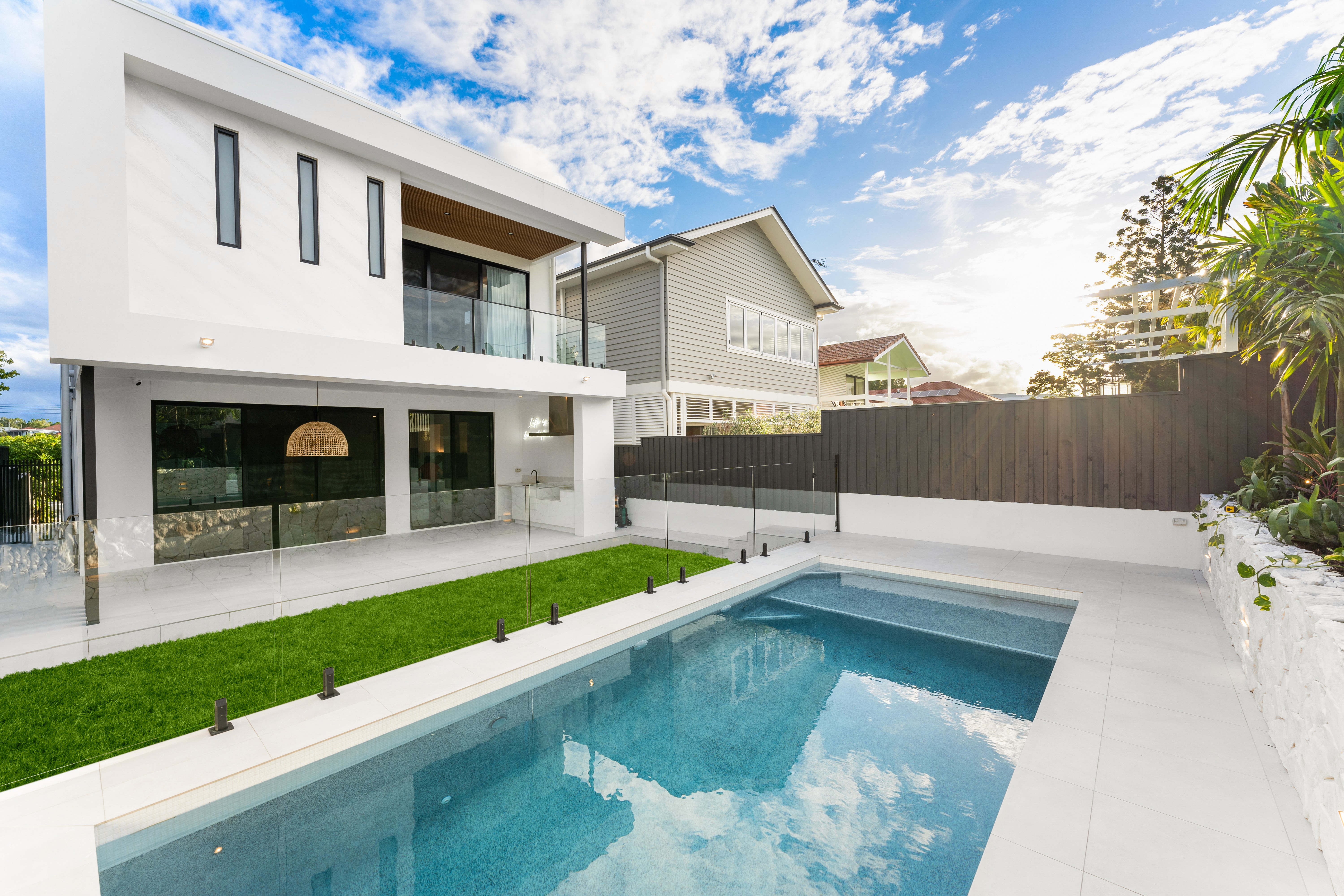 A modern two storey house in Brisbane featuring a minimalist facade, large windows, and a seamlessly integrated outdoor living area.