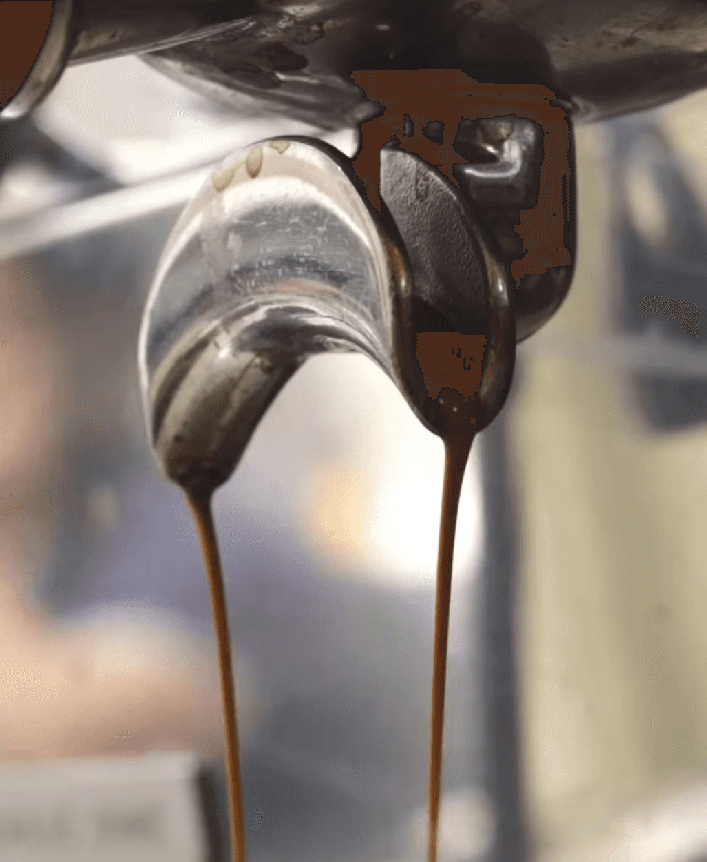 Close-up shot of coffee pouring from a metal spout for Koub promotional assets.