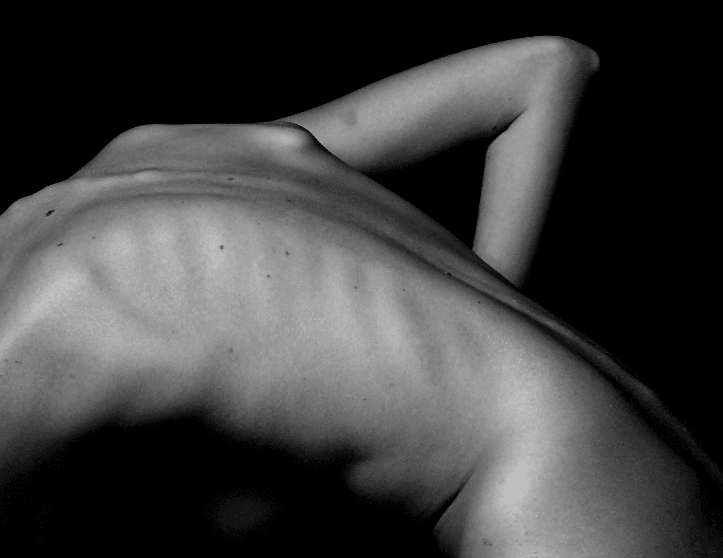 a naked woman sitting on a table with her back to the camera