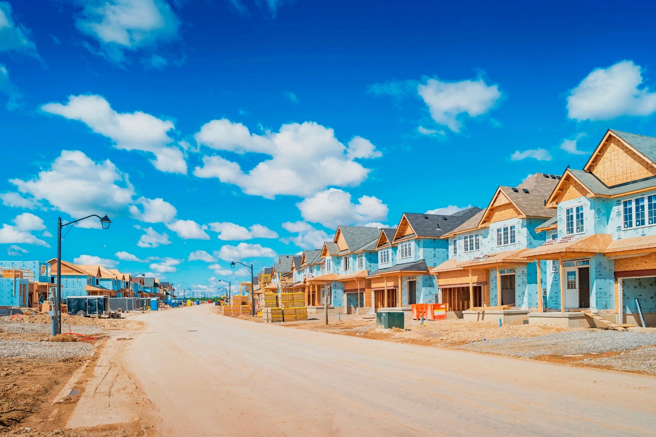Row of residential homes under construction, representing Permit Beacon's advanced construction monitoring and centralized permit tracking to prevent project delays and compliance risks.