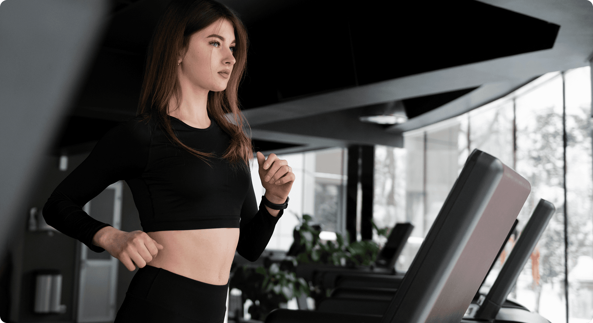 Sporty woman running on treadmill at the gym