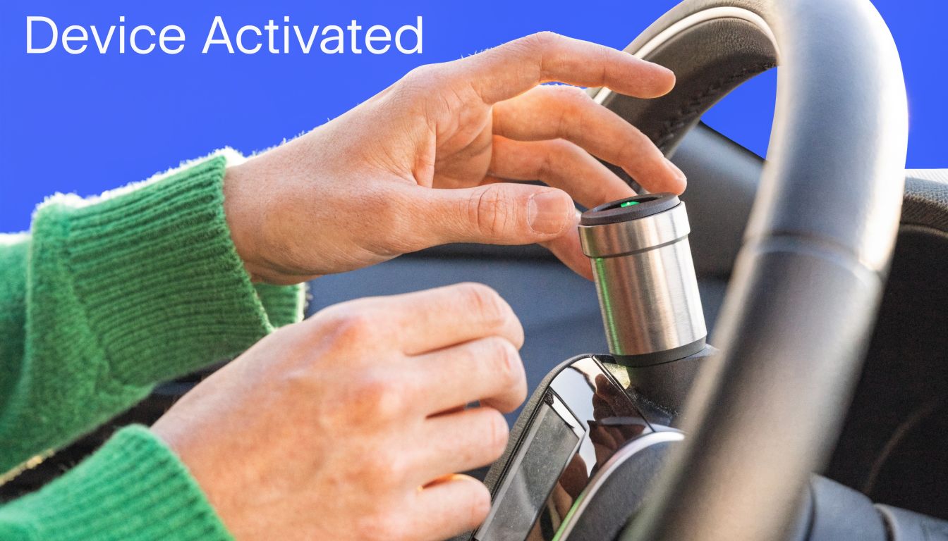 A person using an ignition interlock device installed on a car steering wheel column for safety.
