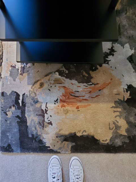 Image of "Abstract patterned rug in living room with white sneakers and modern furniture, KHD Homes interior design."