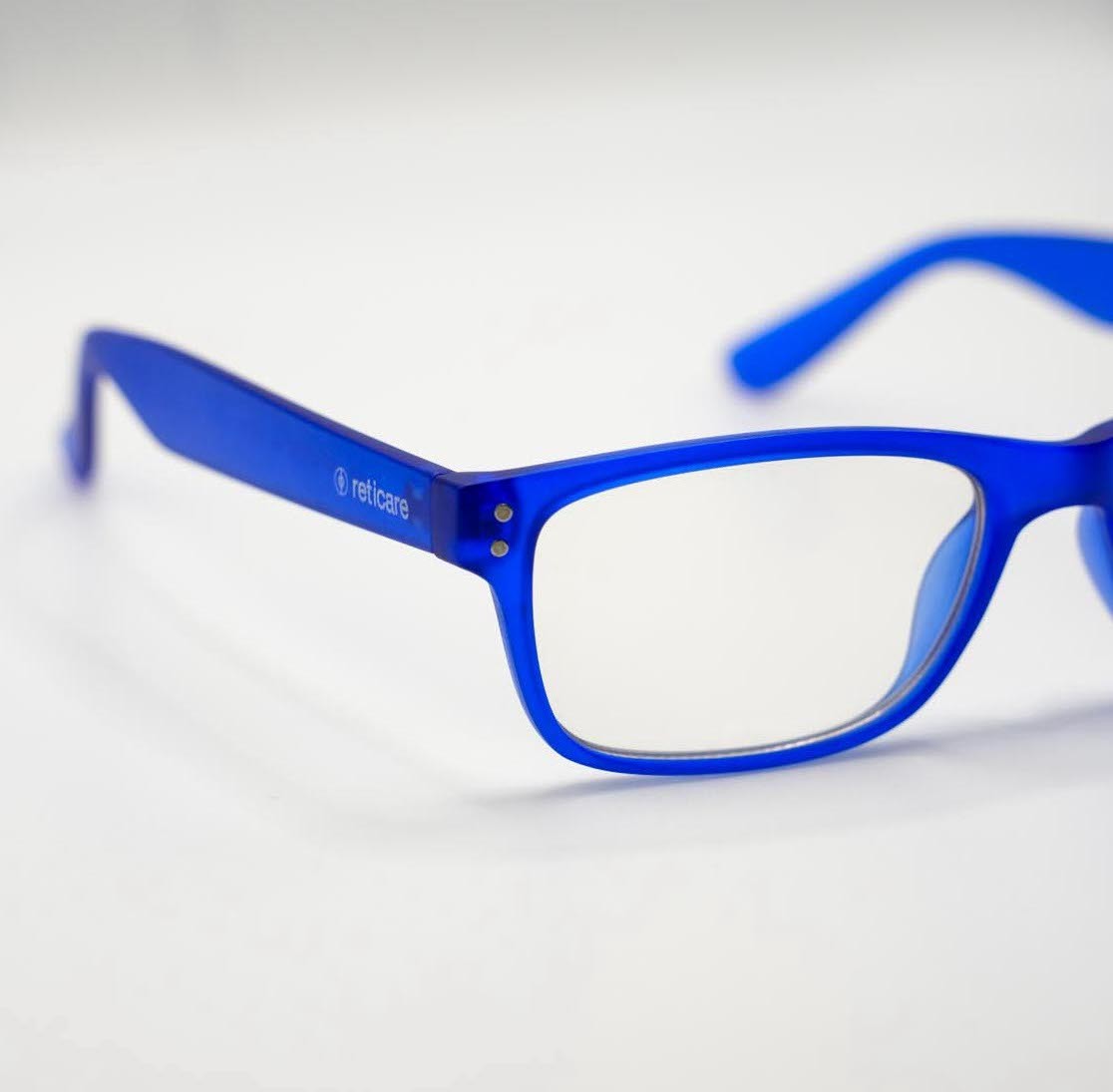 Man in a sporty jacket and light shorts walking across a football field, confidently pulling on his collar.