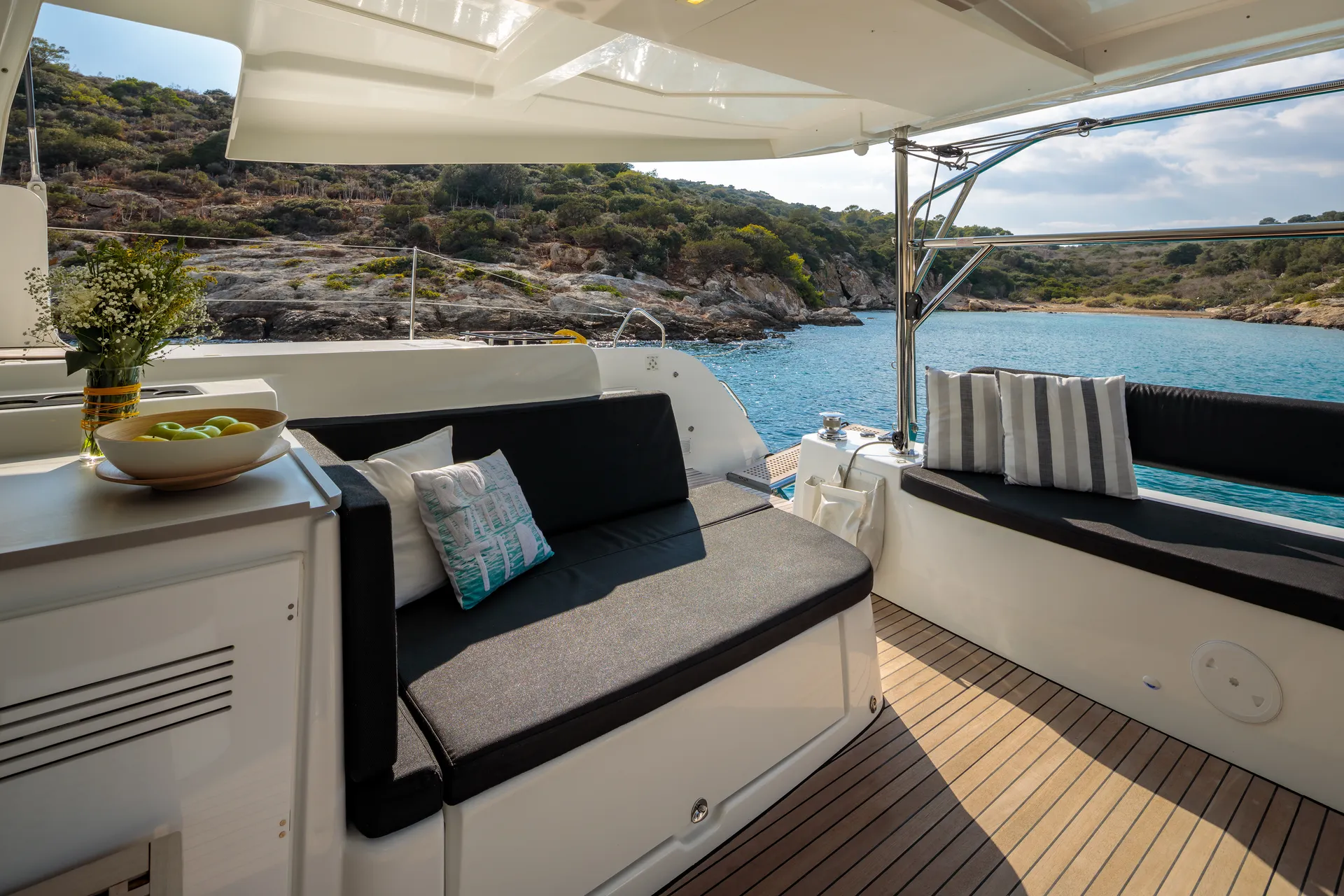 White Rock 36 speedboat with captain at helm cruising calm blue waters near Paros coastline with hills in background.