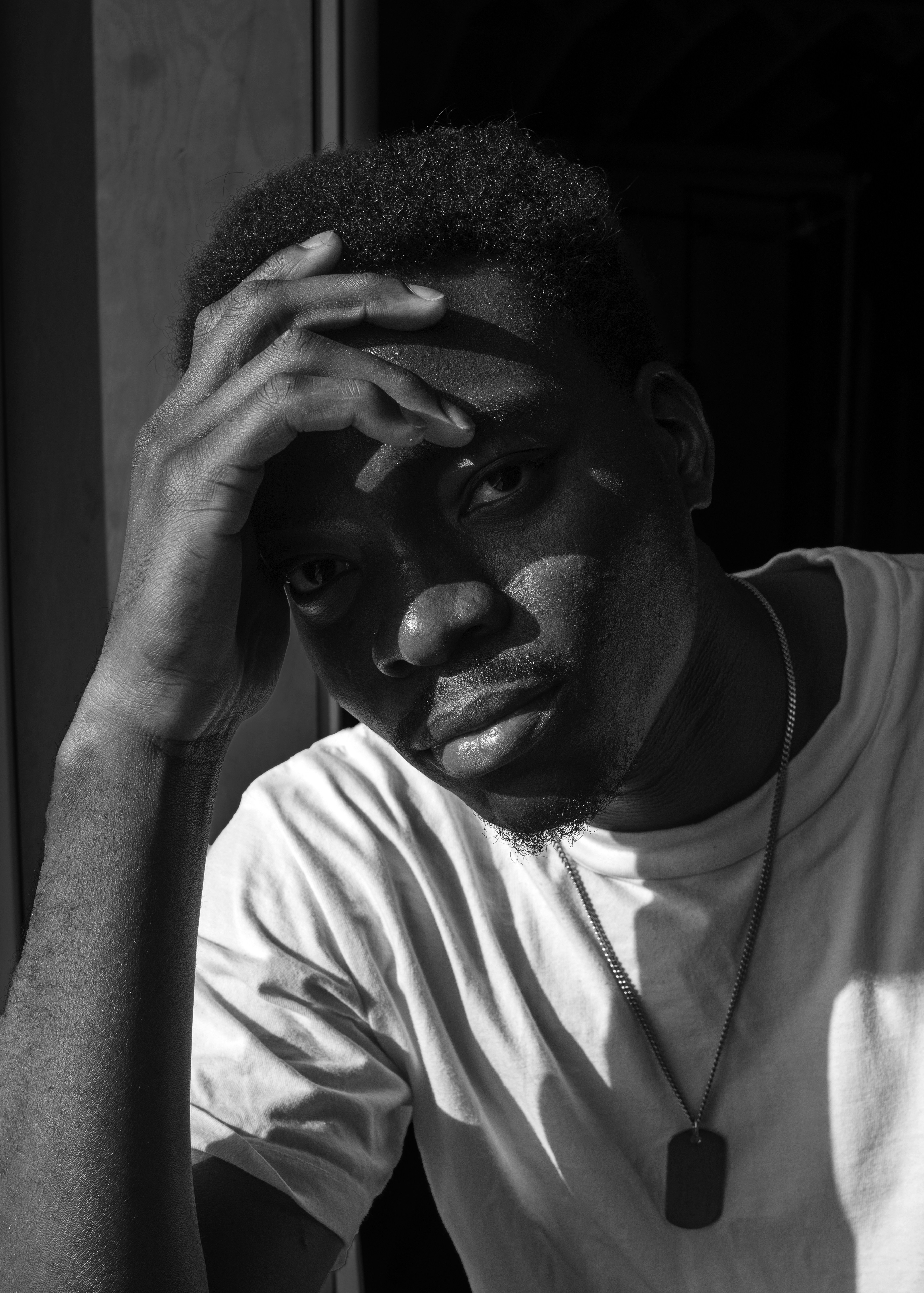 A pensive man poses in sunlight.