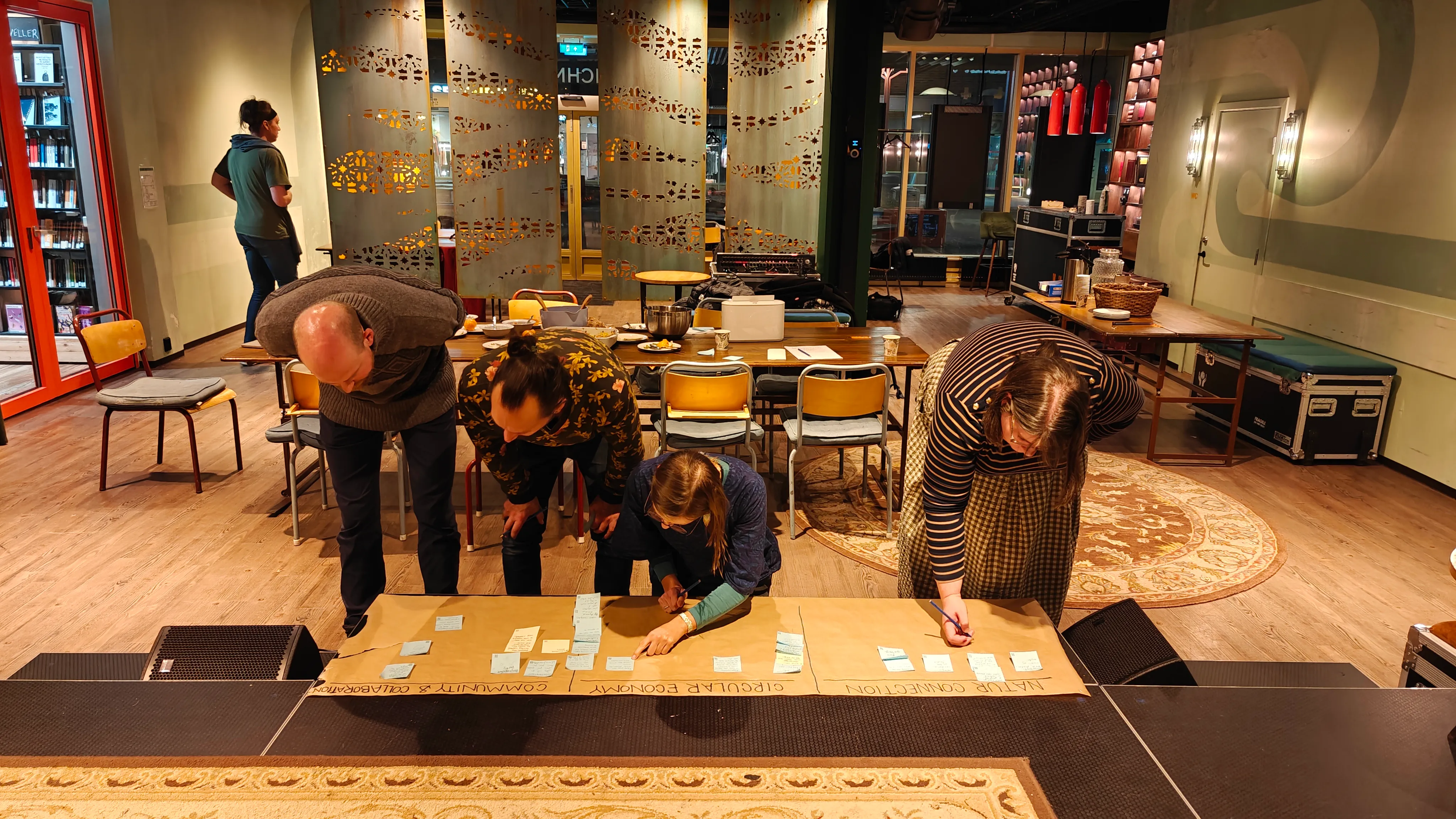People putting down sticky notes on a board