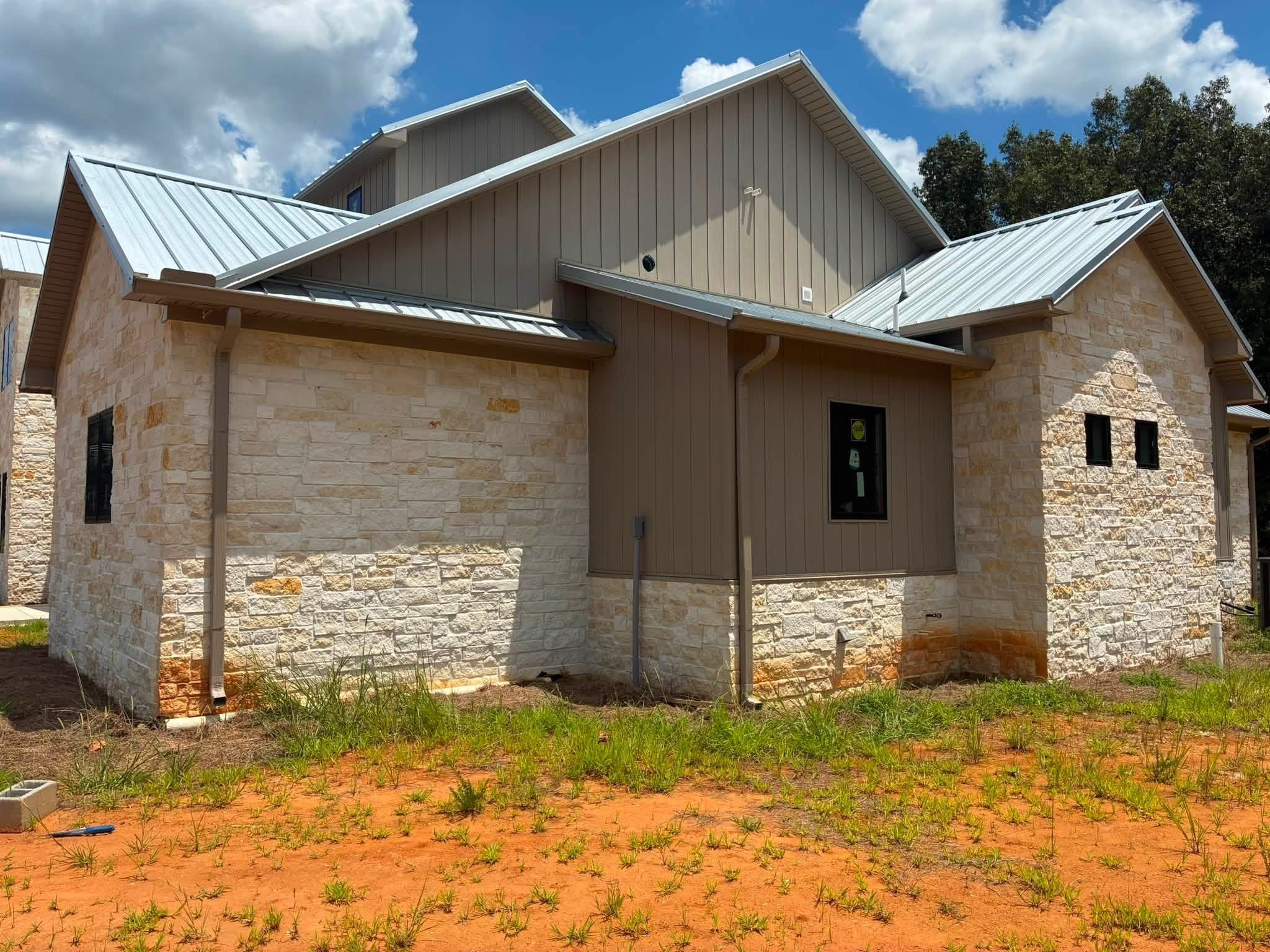Seamless gutters on a custom stone home with a metal roof in Starkville, MS