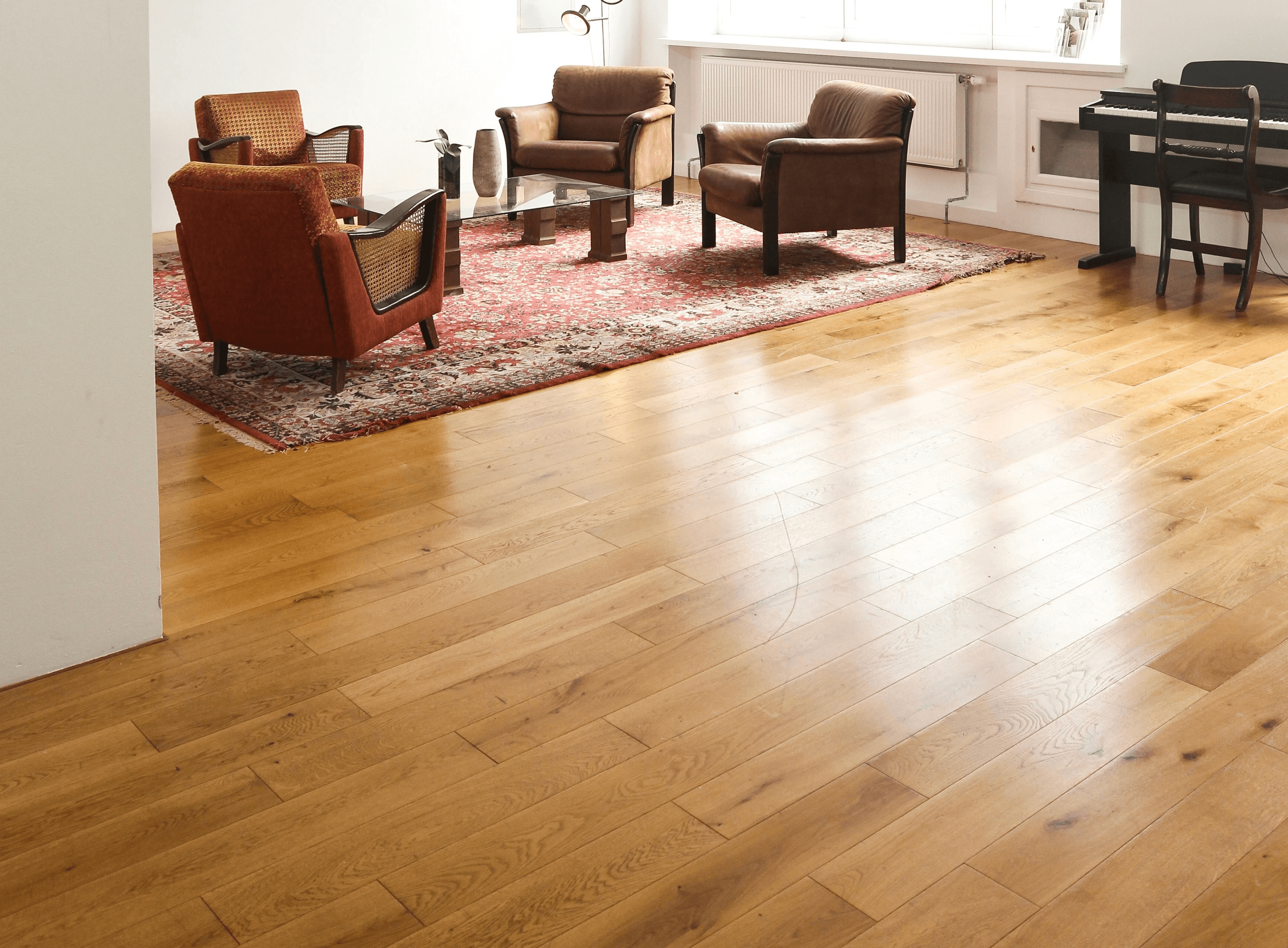living room with brown wooden parquet floor and white wall