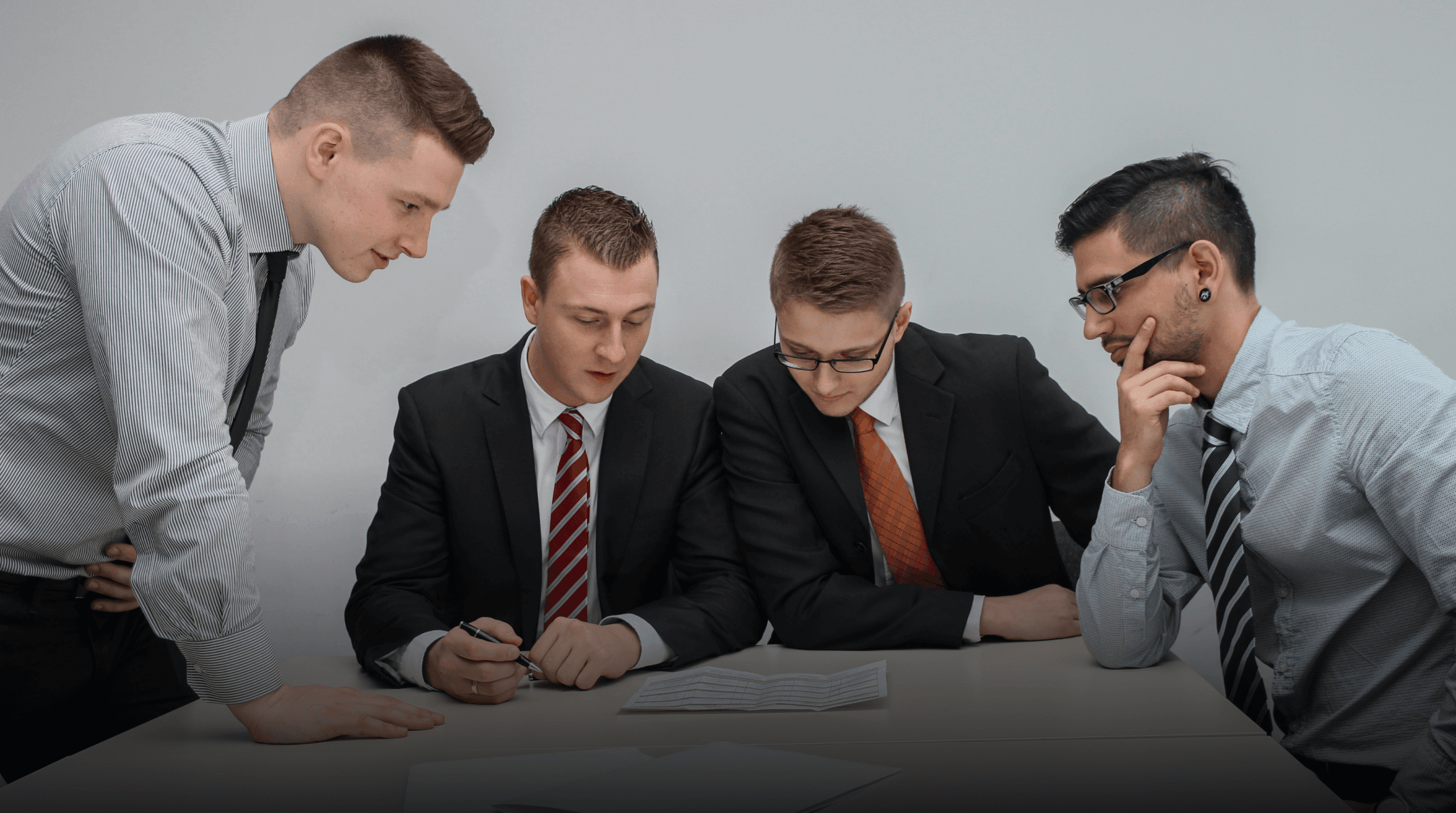 A group of people sitting around a table in a meeting.