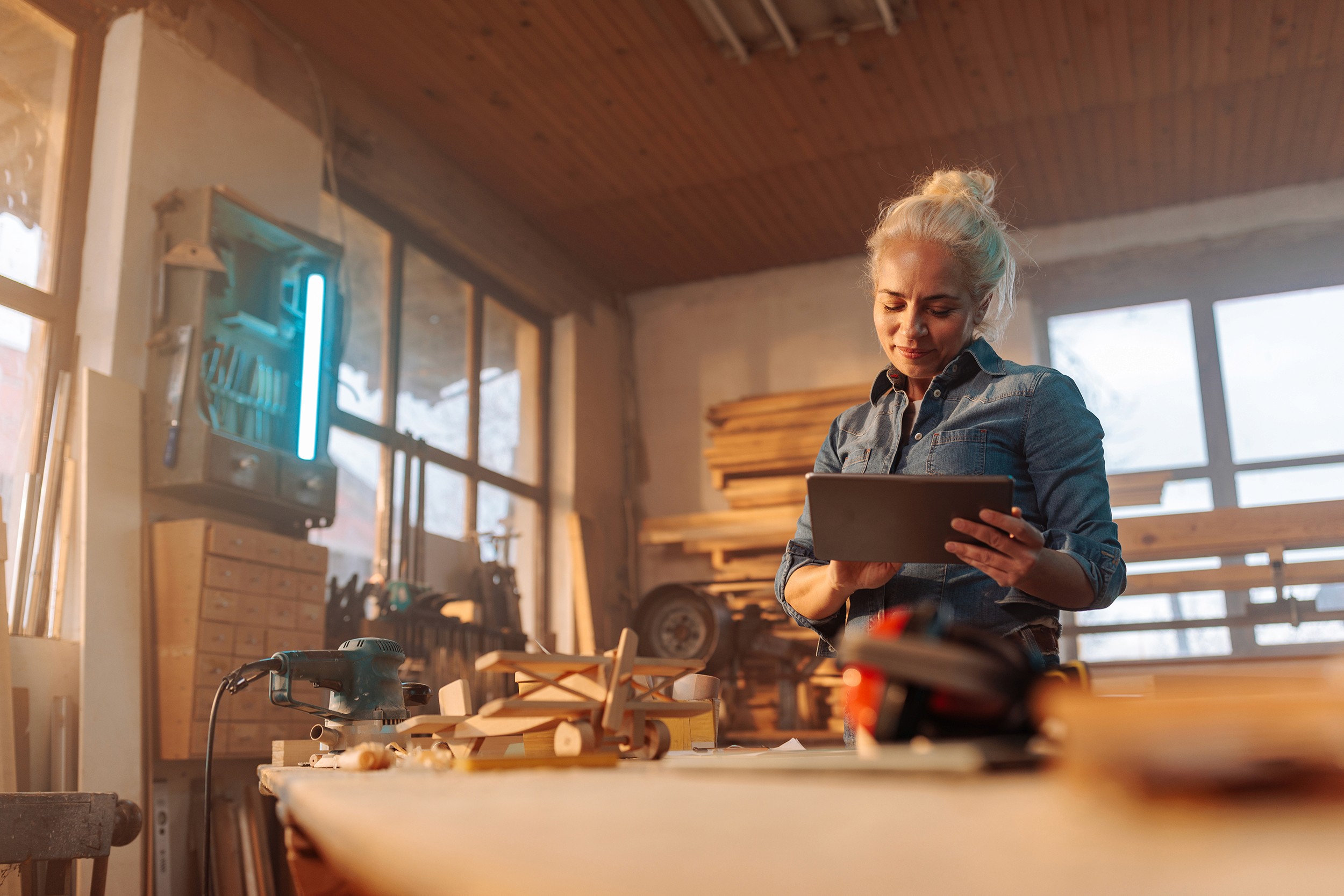 Photo of female designer in wood workshop. 