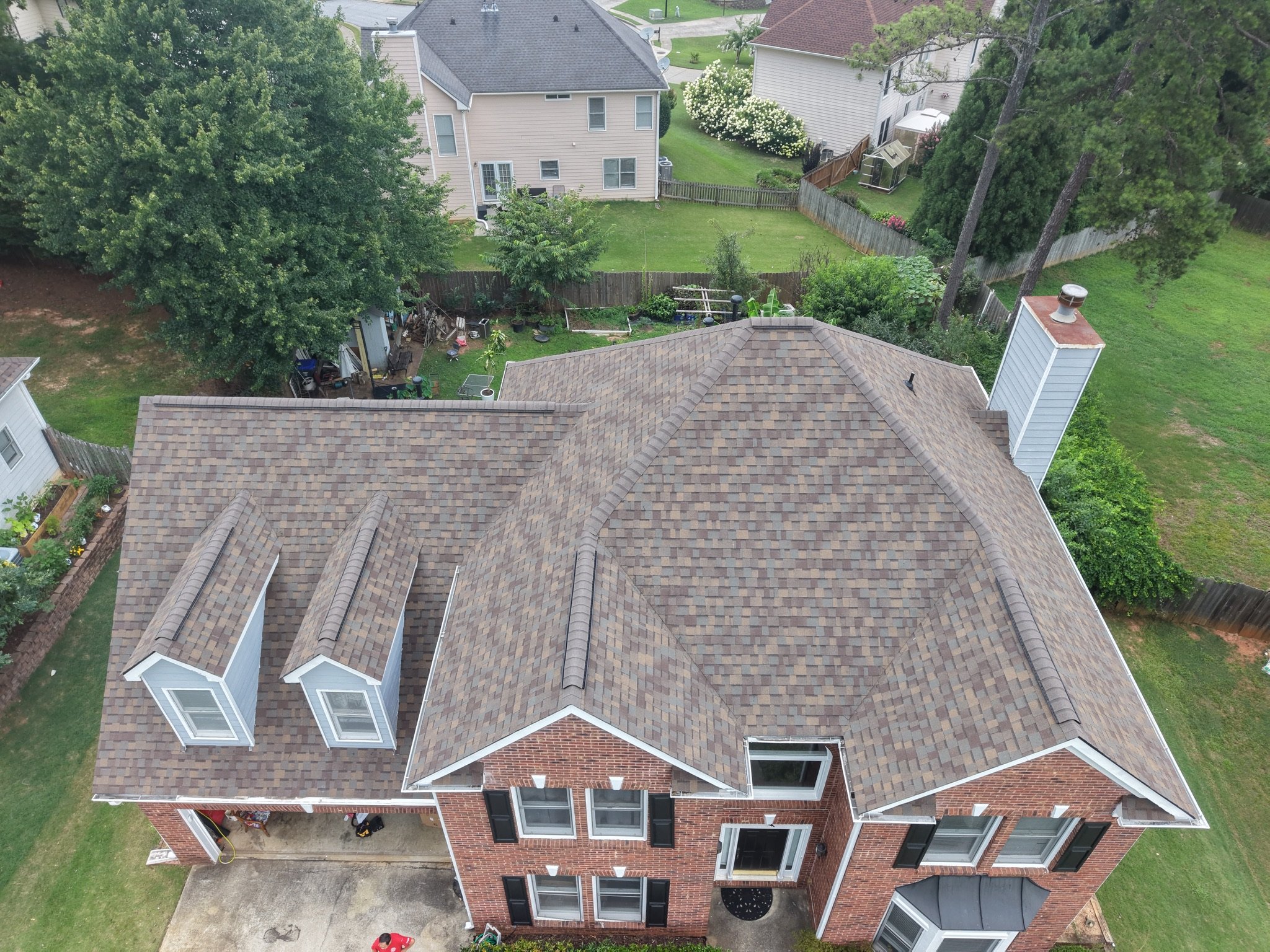 Aerial view of the finished roof replacement on a two-story brick home in Lawrenceville, GA