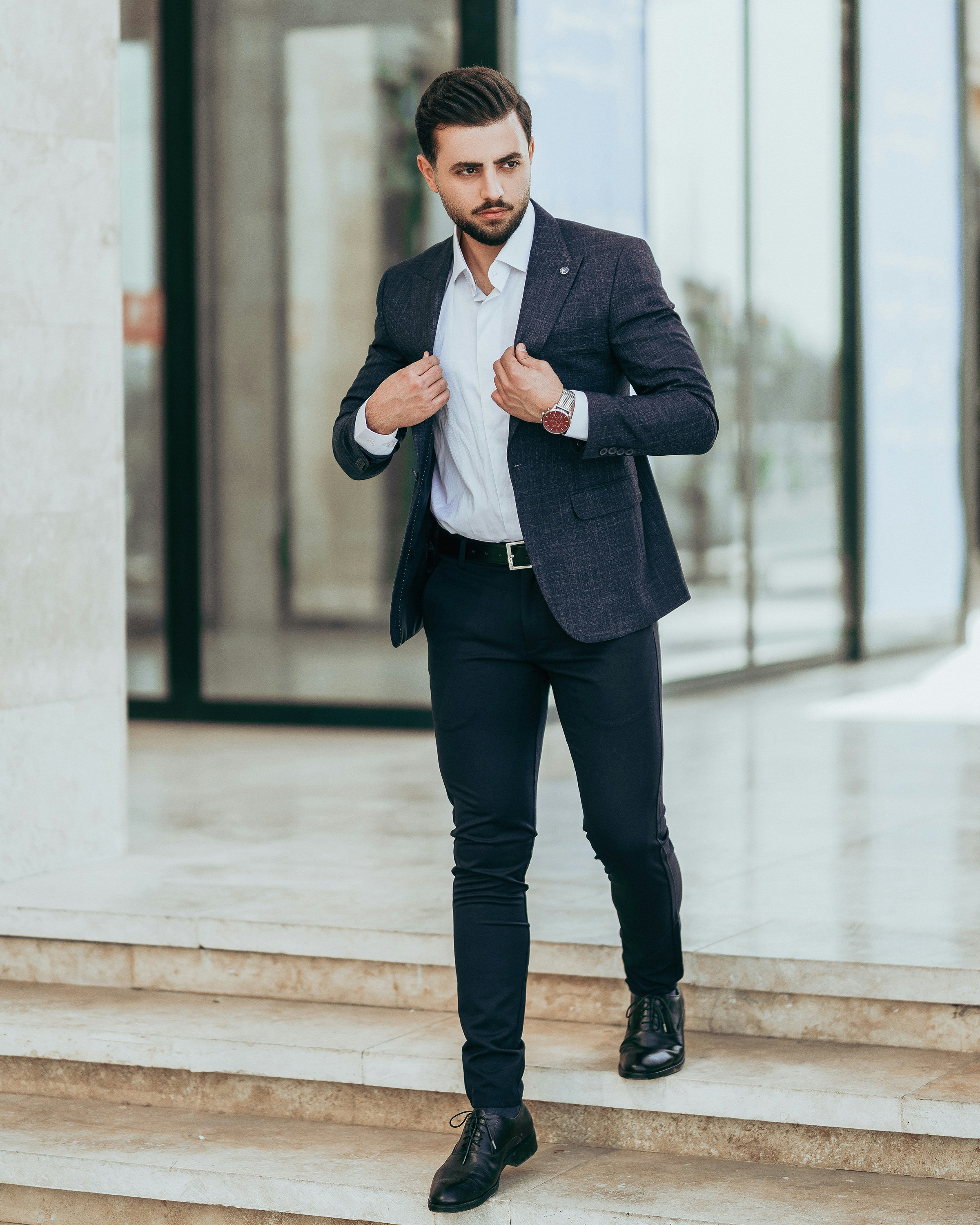 a man in a suit and tie standing on steps