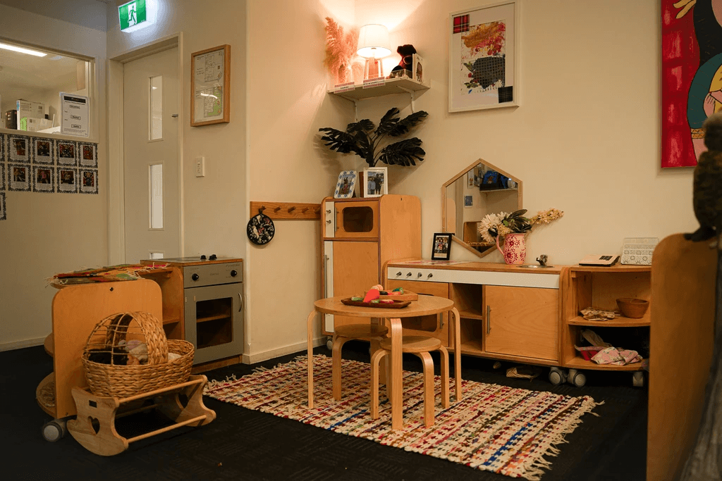 Young children engage in supervised water play with a teacher in an outdoor early childhood environment.