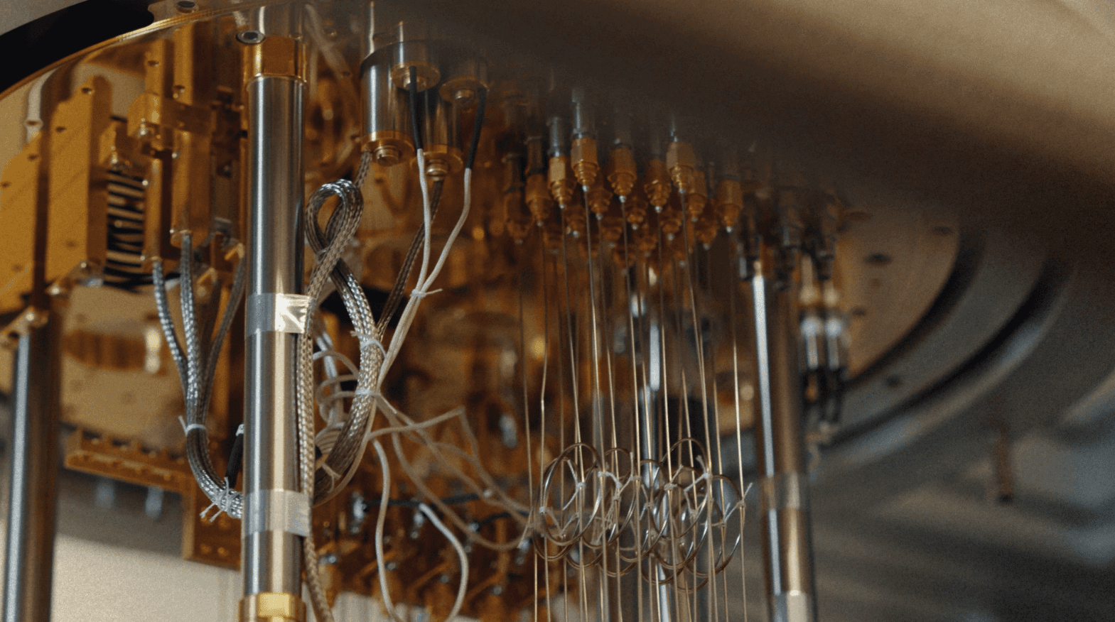 Gold experimental cryogenic quantum device with dense wiring mounted in a cleanroom lab, supporting deep tech marketing for advanced systems.