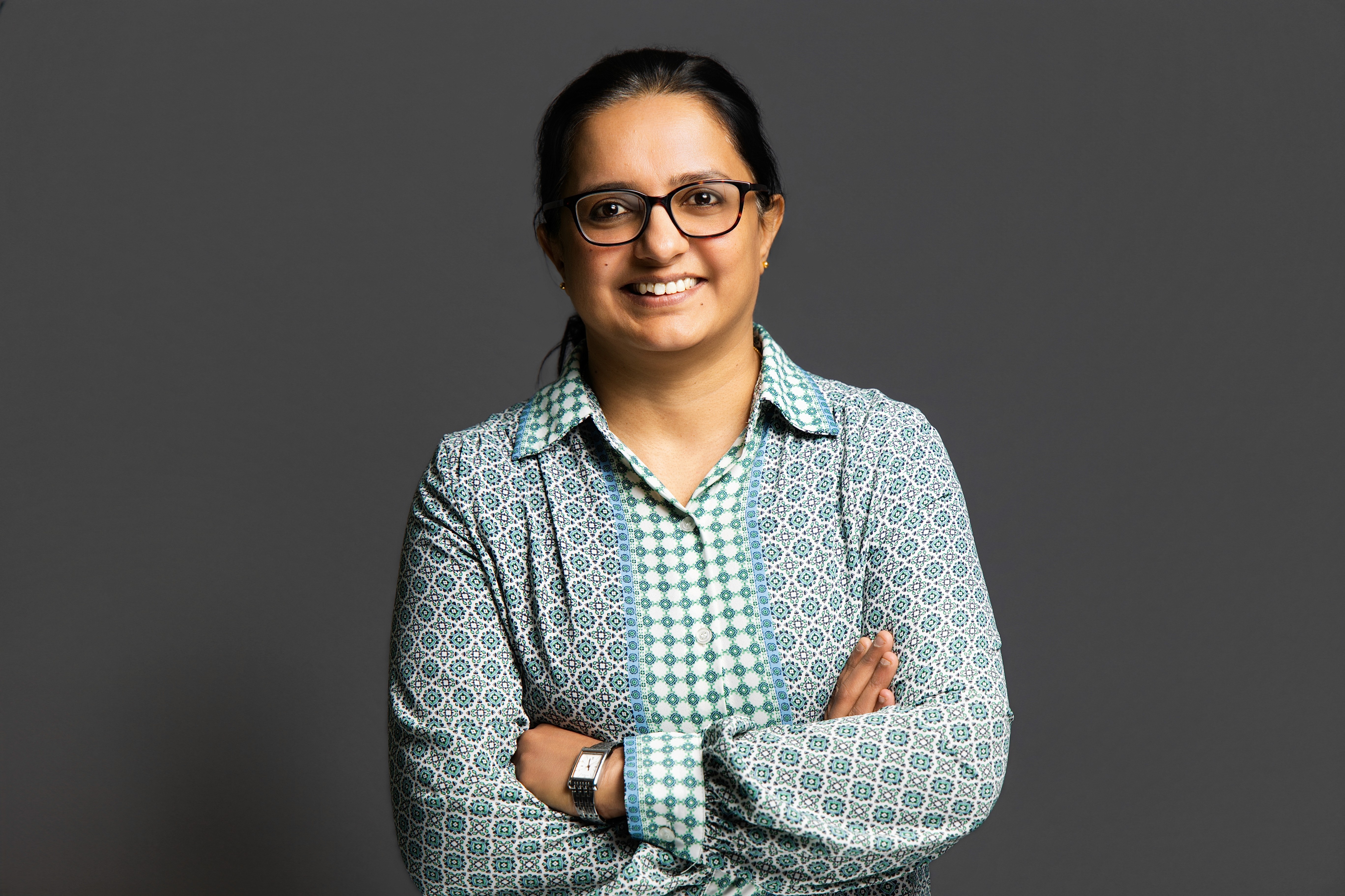 A young man in a white t-shirt stands against a light-colored background.