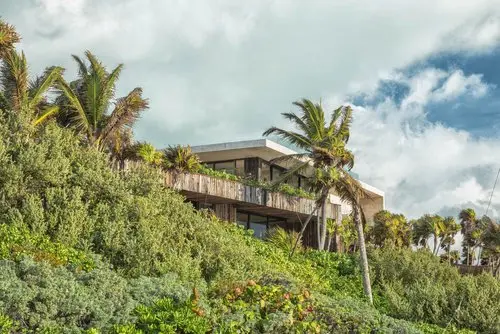 Exterior view of Casa Sastran Villa showcasing beautiful architecture amidst jungle and palm trees.